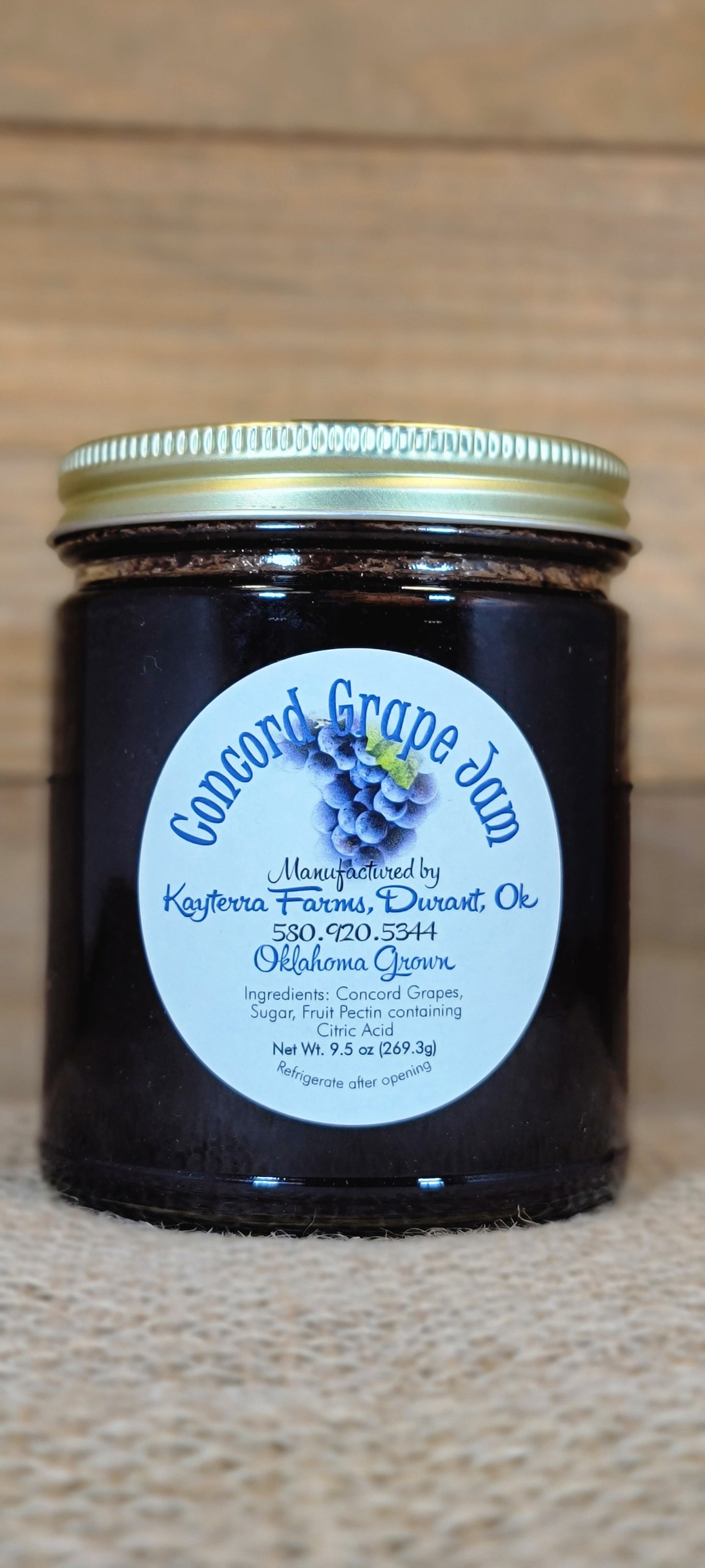 A jar of Concord Grape Jam made from locally grown fruit, showcasing its rich purple color and texture.