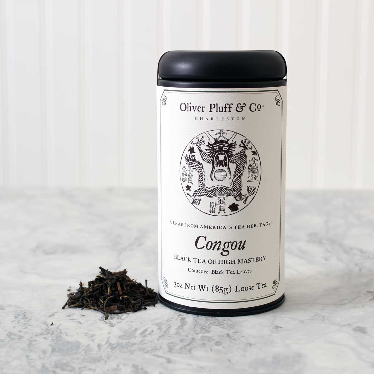 A matte black tin of Congou Loose Tea, showcasing its elegant packaging and rich tea leaves inside.