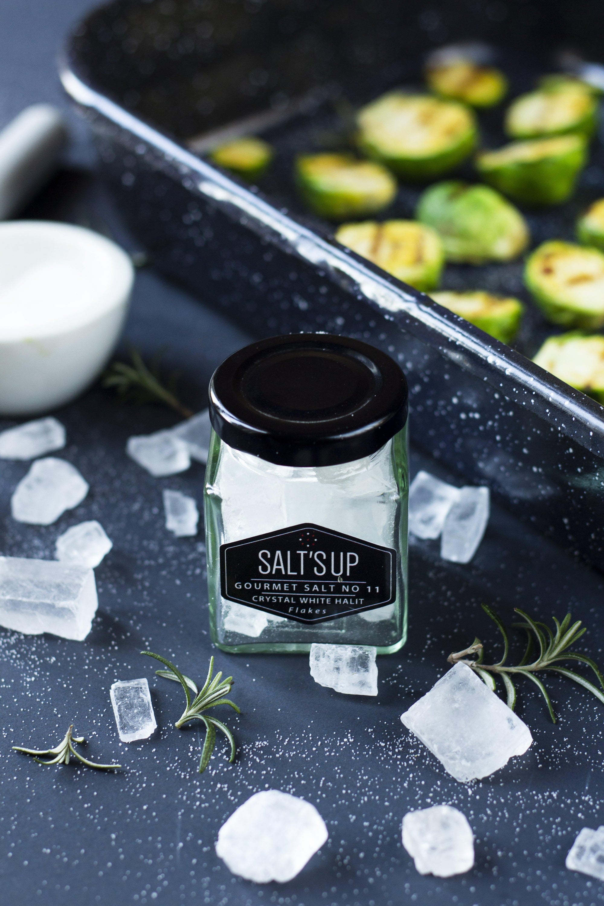 A jar of CRYSTAL WHITE salt diamonds showcasing crystal clear, small salt pieces, perfect for seasoning.