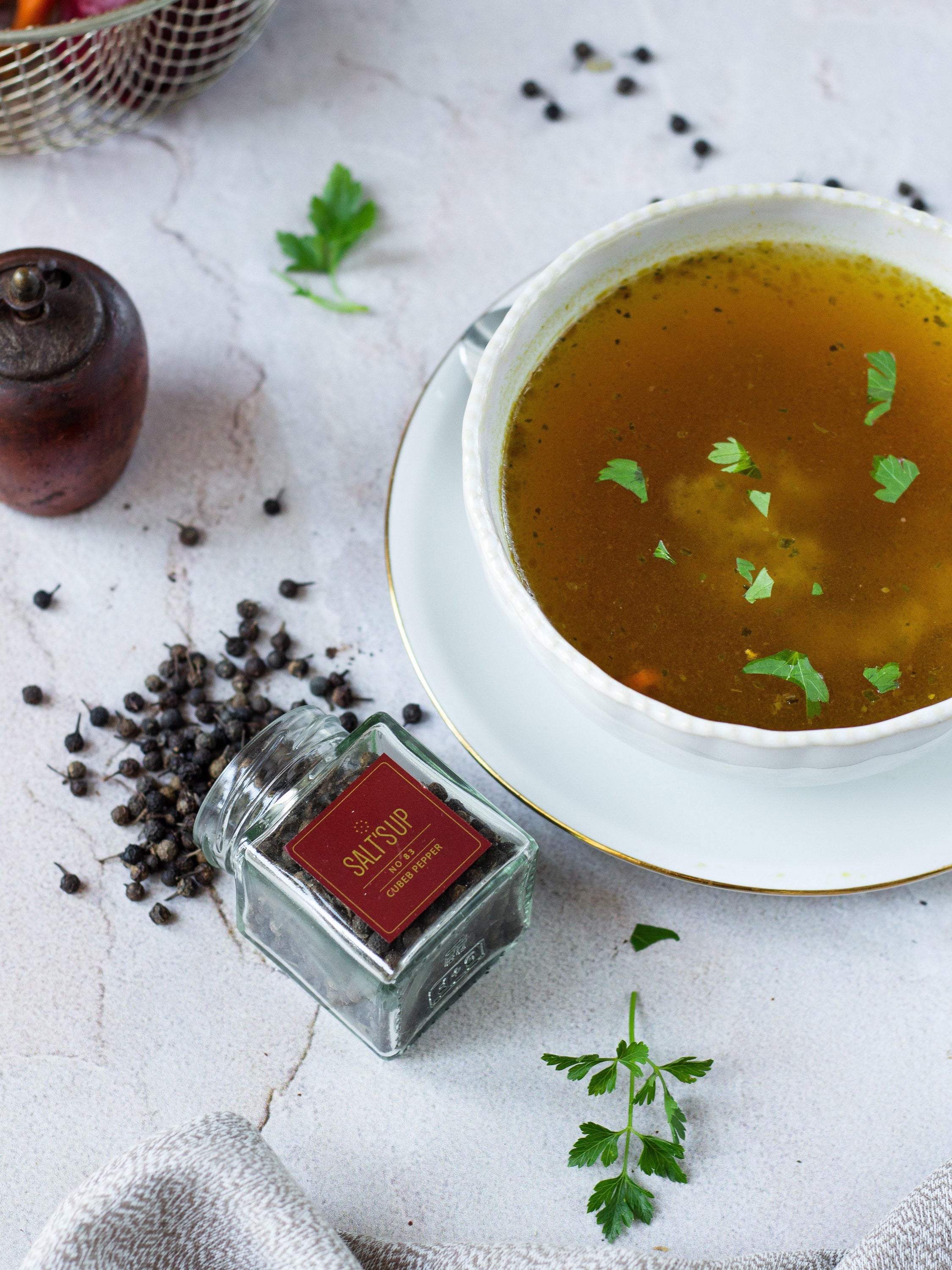 Dried CUBEB pepper berries with attached stalks, showcasing their unique appearance and color.