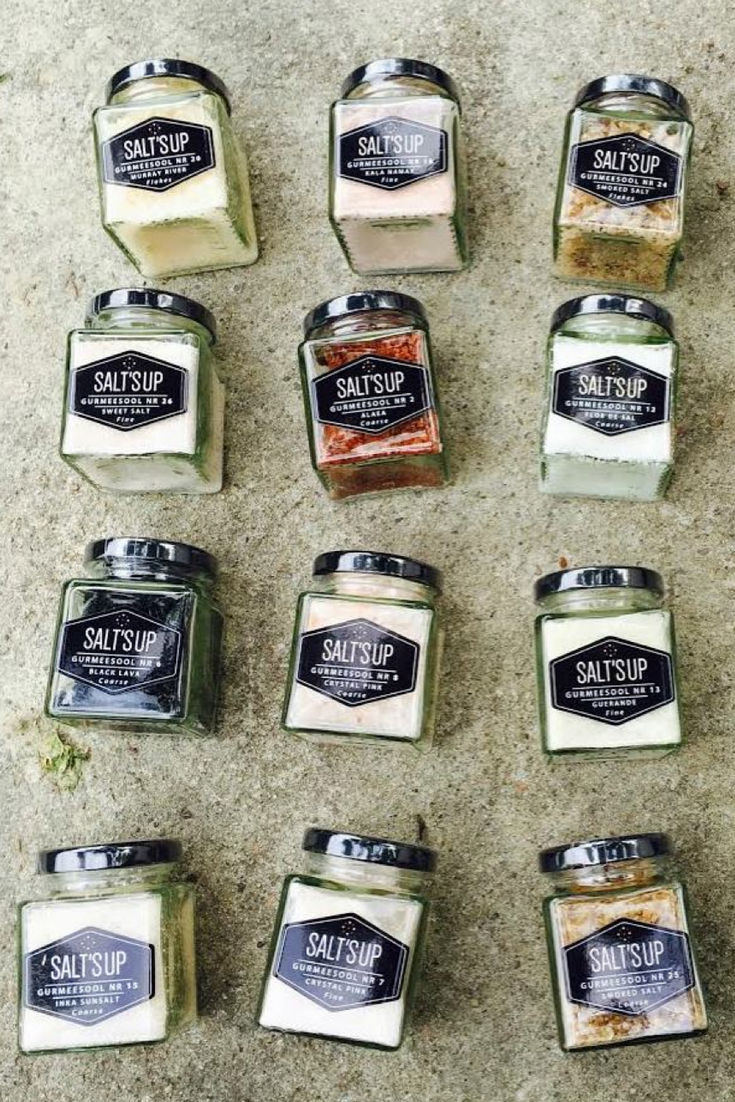 A jar of Cyprus Crystal White salt flakes showcasing large pyramid-shaped crystals, ideal for culinary use.