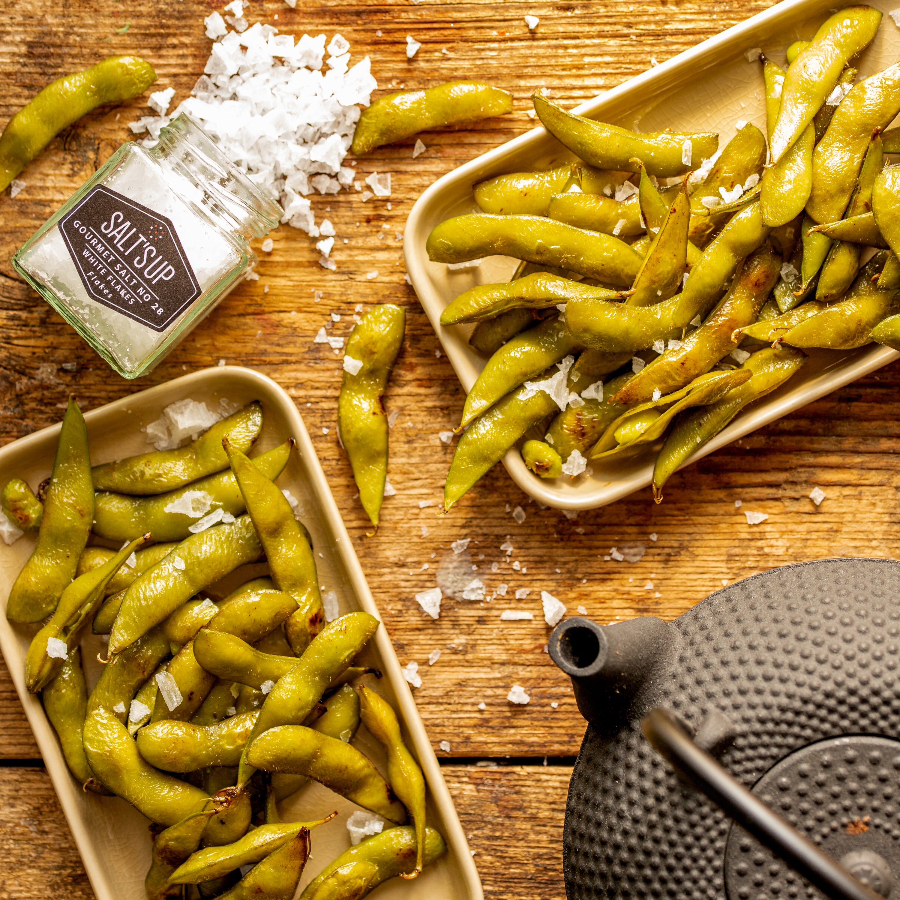 A jar of Cyprus Crystal White salt flakes showcasing large pyramid-shaped crystals, ideal for culinary use.