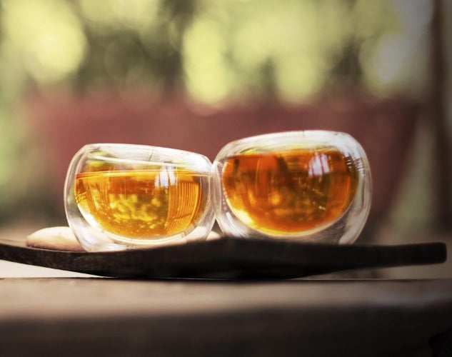 Elegant double walled kava tea cups showcasing a floating liquid illusion, perfect for tea and desserts.