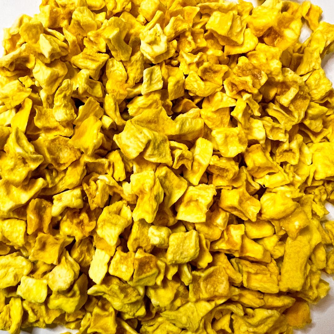A bowl of vibrant freeze dried mango cubes, showcasing their bright yellow color and natural texture, perfect for snacking or baking.