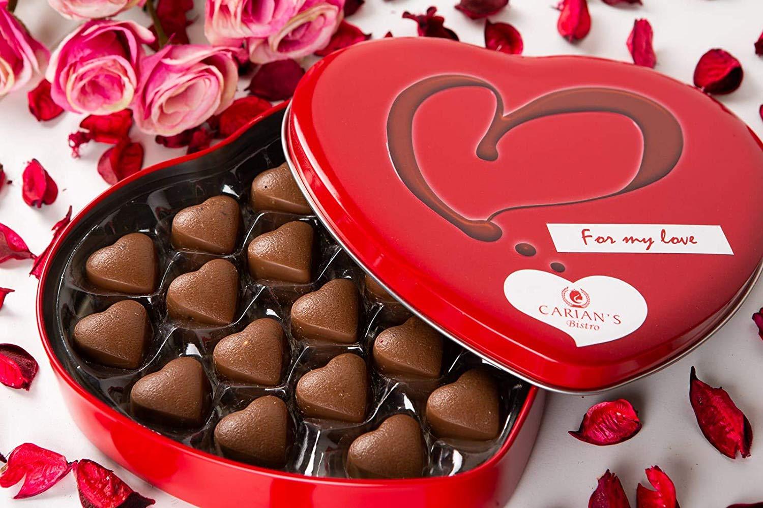 A luxurious metal tin filled with assorted gourmet chocolates, including milk and dark chocolate hearts, beautifully arranged for Valentine's Day.