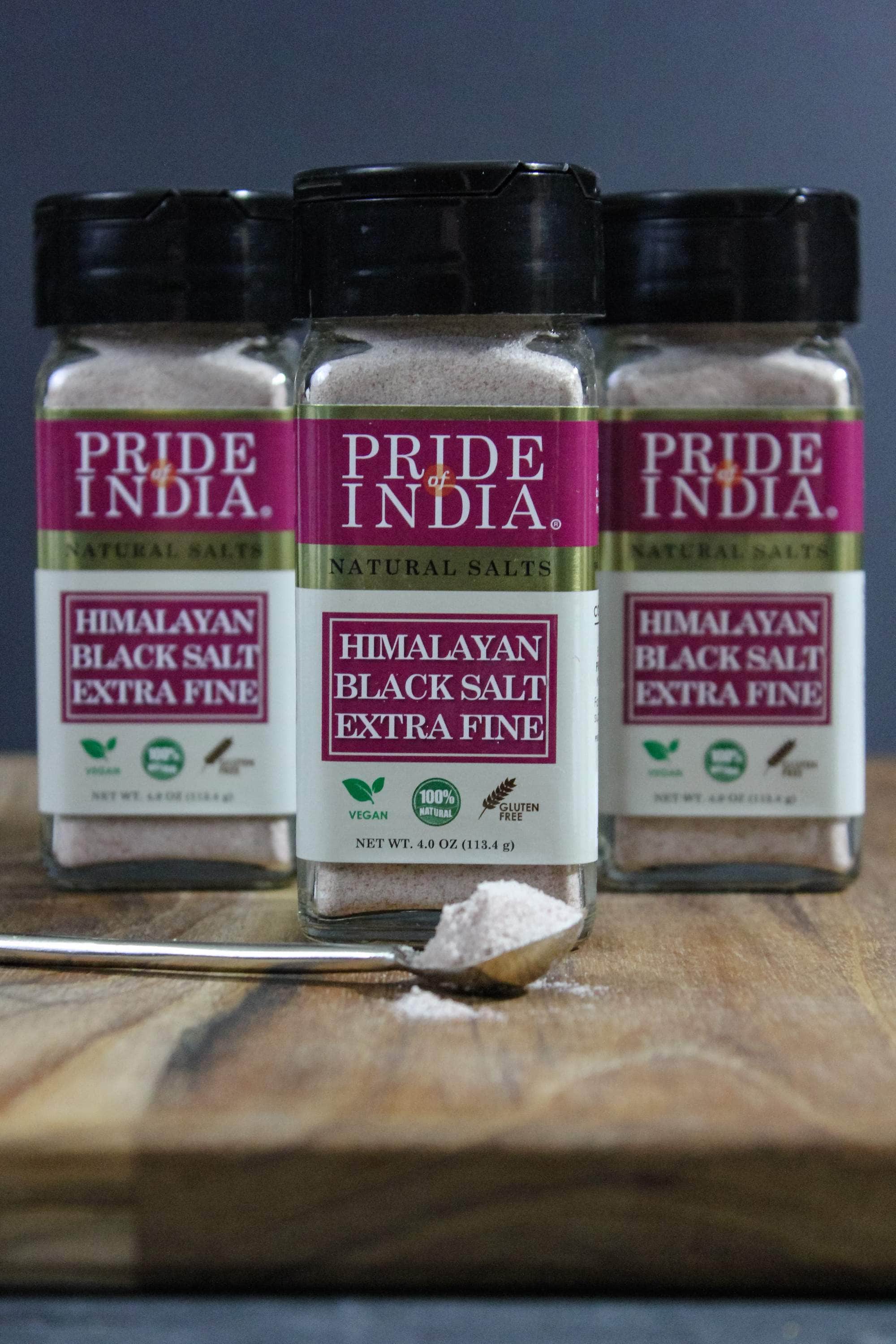 A jar of Pride of India Himalayan Black Rock Salt (Kala Namak) - Extra Fine Grind showcasing its blackish-brown color and fine texture.
