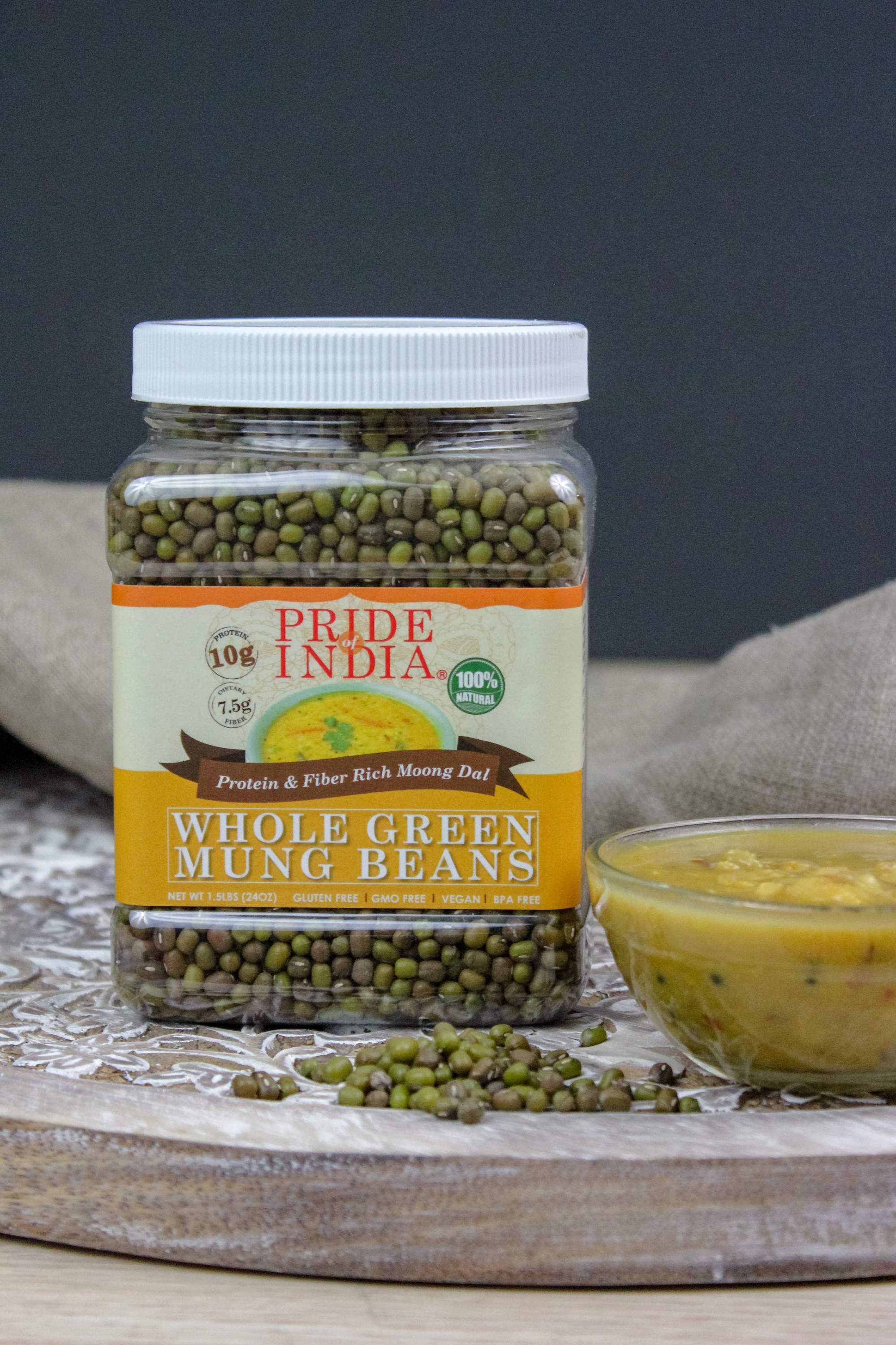 A jar of Indian Whole Green Mung Gram, showcasing its rich green color and healthy appearance, perfect for cooking and sprouting.