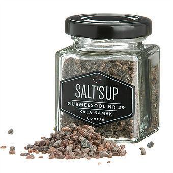 A jar of KALA NAMAK coarse salt showcasing its brownish-pink color, ideal for vegan cooking and rich in minerals.