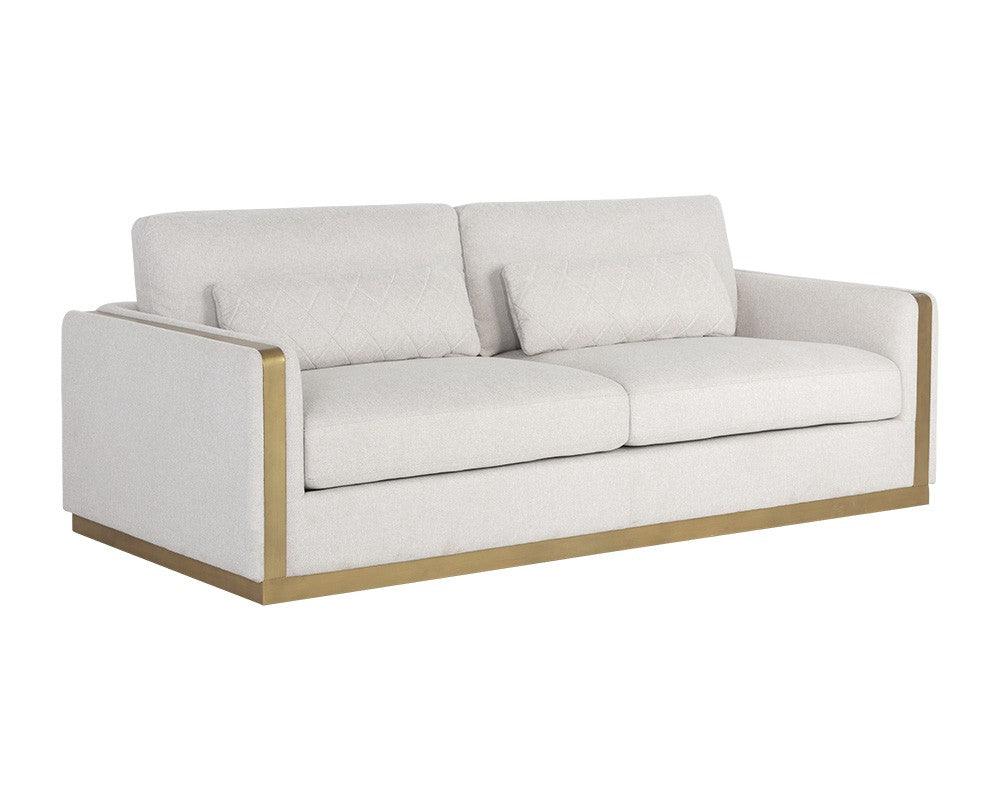 Lean Sofa in Belfast Oatmeal fabric with brass-finished steel legs and quilted pillows, showcasing modern design and comfort.