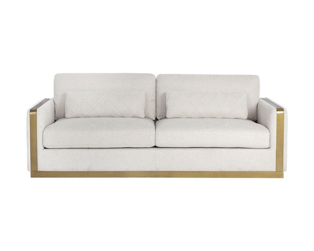 Lean Sofa in Belfast Oatmeal fabric with brass-finished steel legs and quilted pillows, showcasing modern design and comfort.