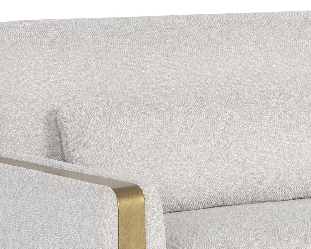 Lean Sofa in Belfast Oatmeal fabric with brass-finished steel legs and quilted pillows, showcasing modern design and comfort.