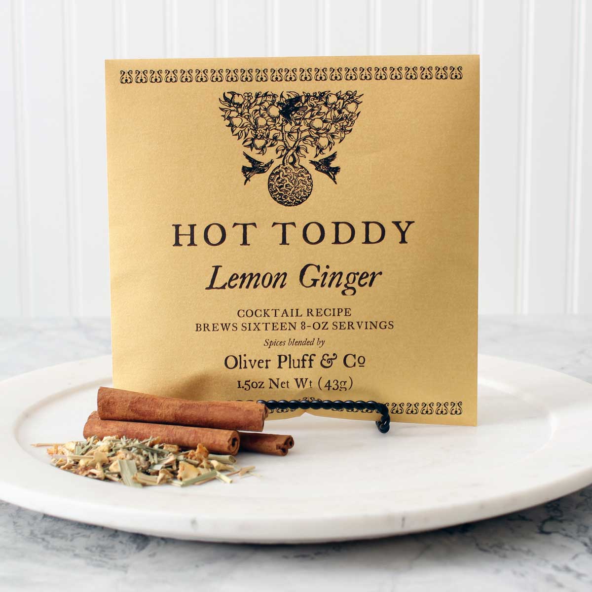 A steaming cup of Lemon Ginger Hot Toddy with spices and a cinnamon stick, showcasing the warm and inviting beverage.