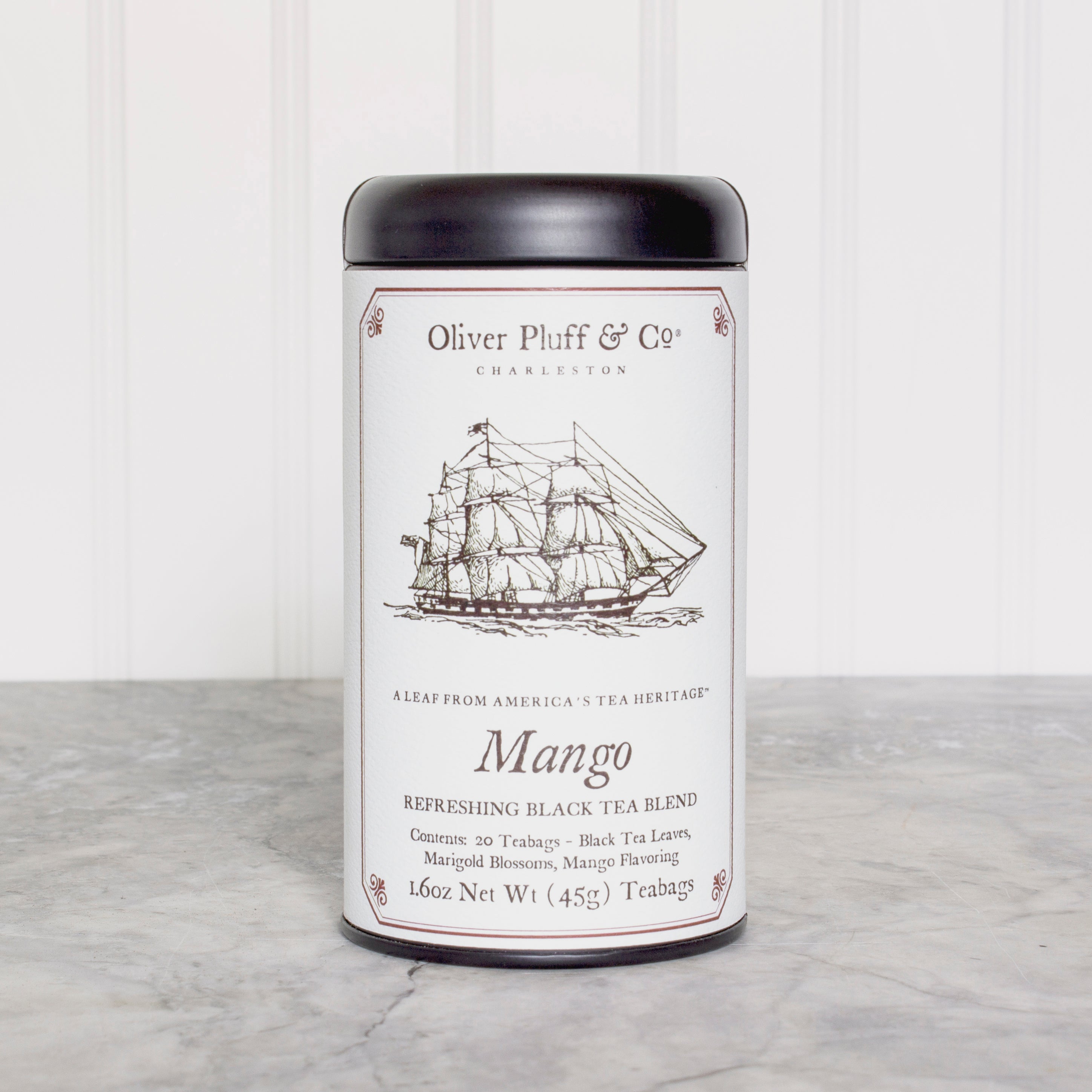 A stylish matte black tea tin filled with Mango Teabags, showcasing the elegant packaging and vibrant mango theme.