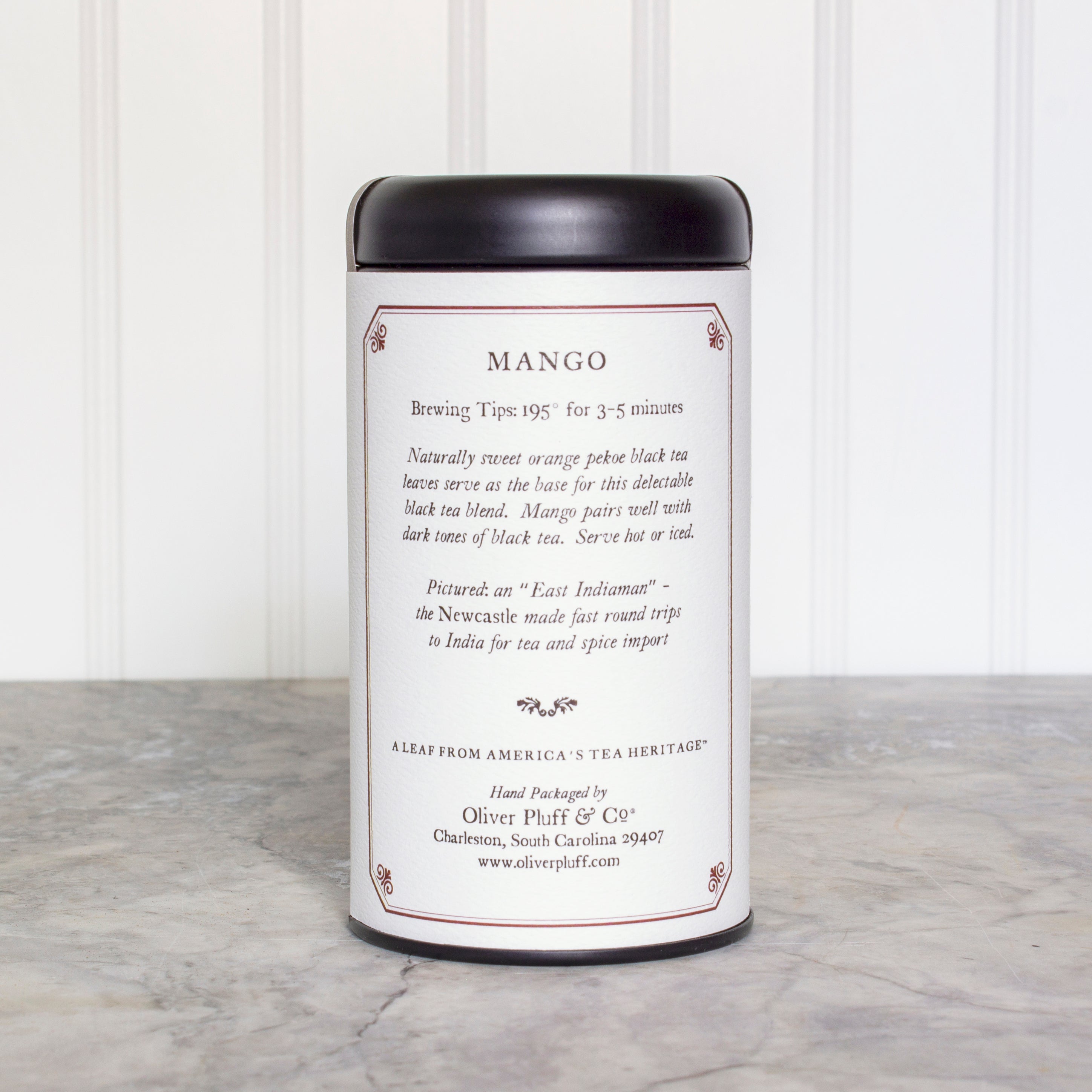 A stylish matte black tea tin filled with Mango Teabags, showcasing the elegant packaging and vibrant mango theme.