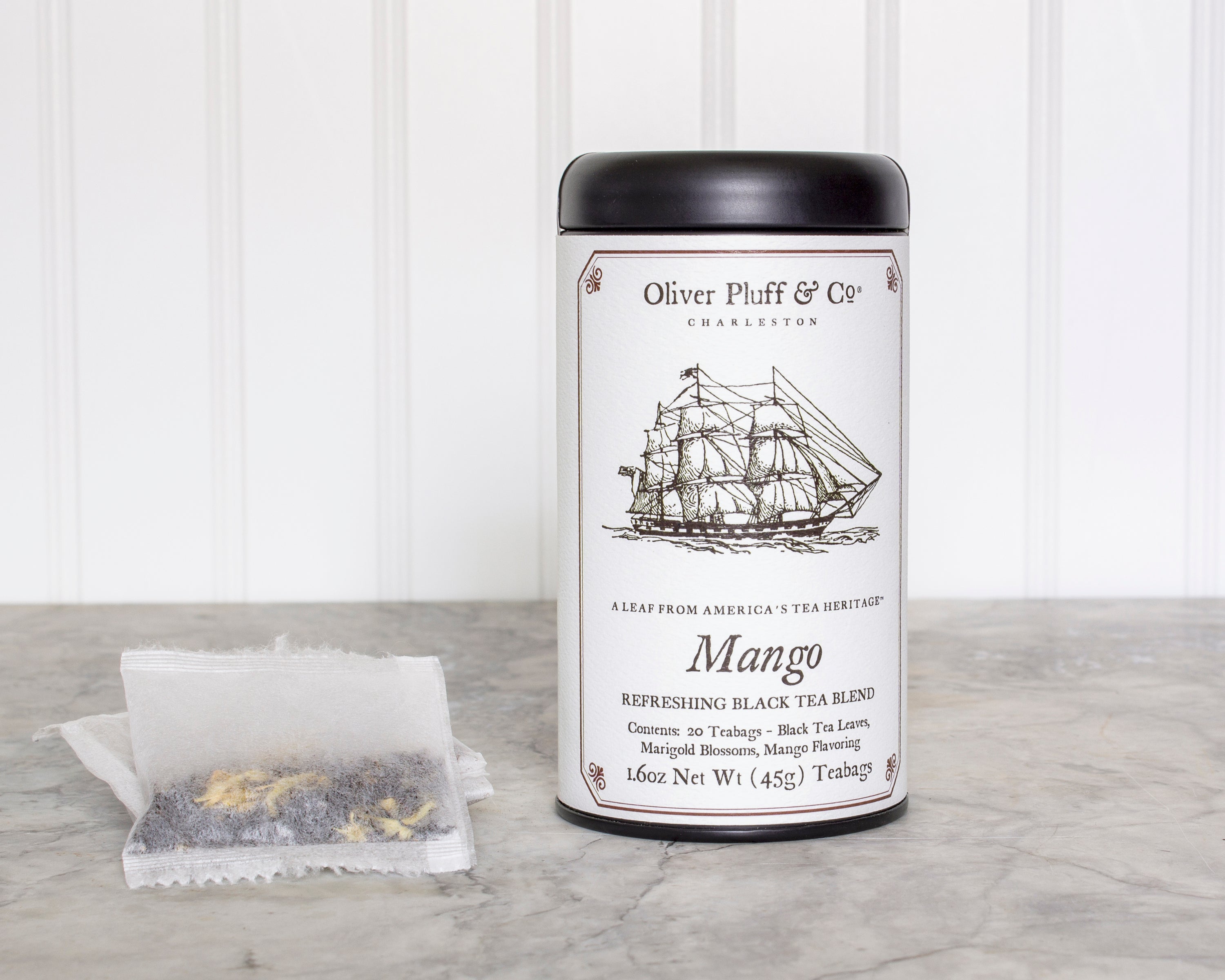 A stylish matte black tea tin filled with Mango Teabags, showcasing the elegant packaging and vibrant mango theme.