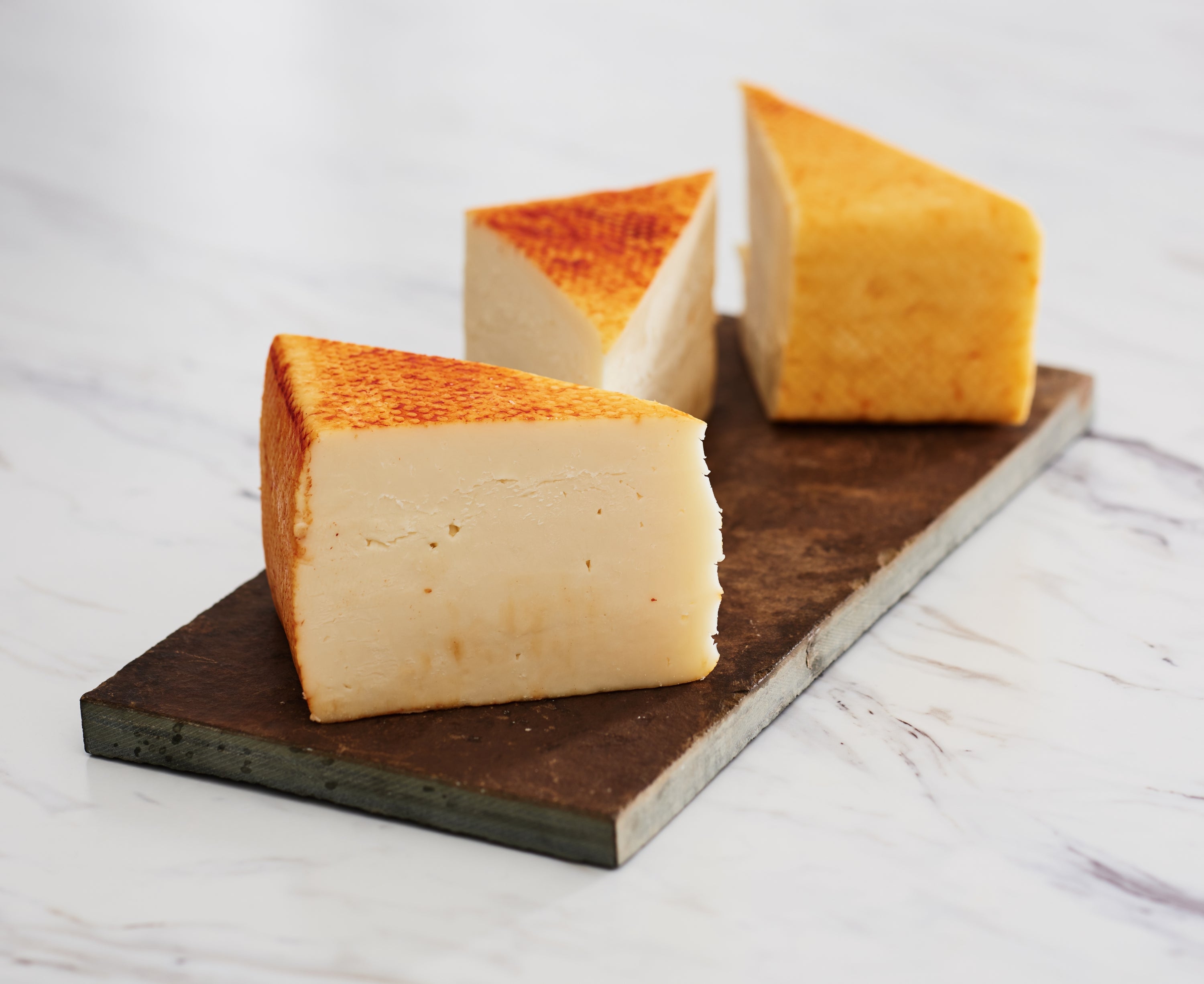 Wisconsin Muenster cheese block, semi-soft texture, ideal for slicing.