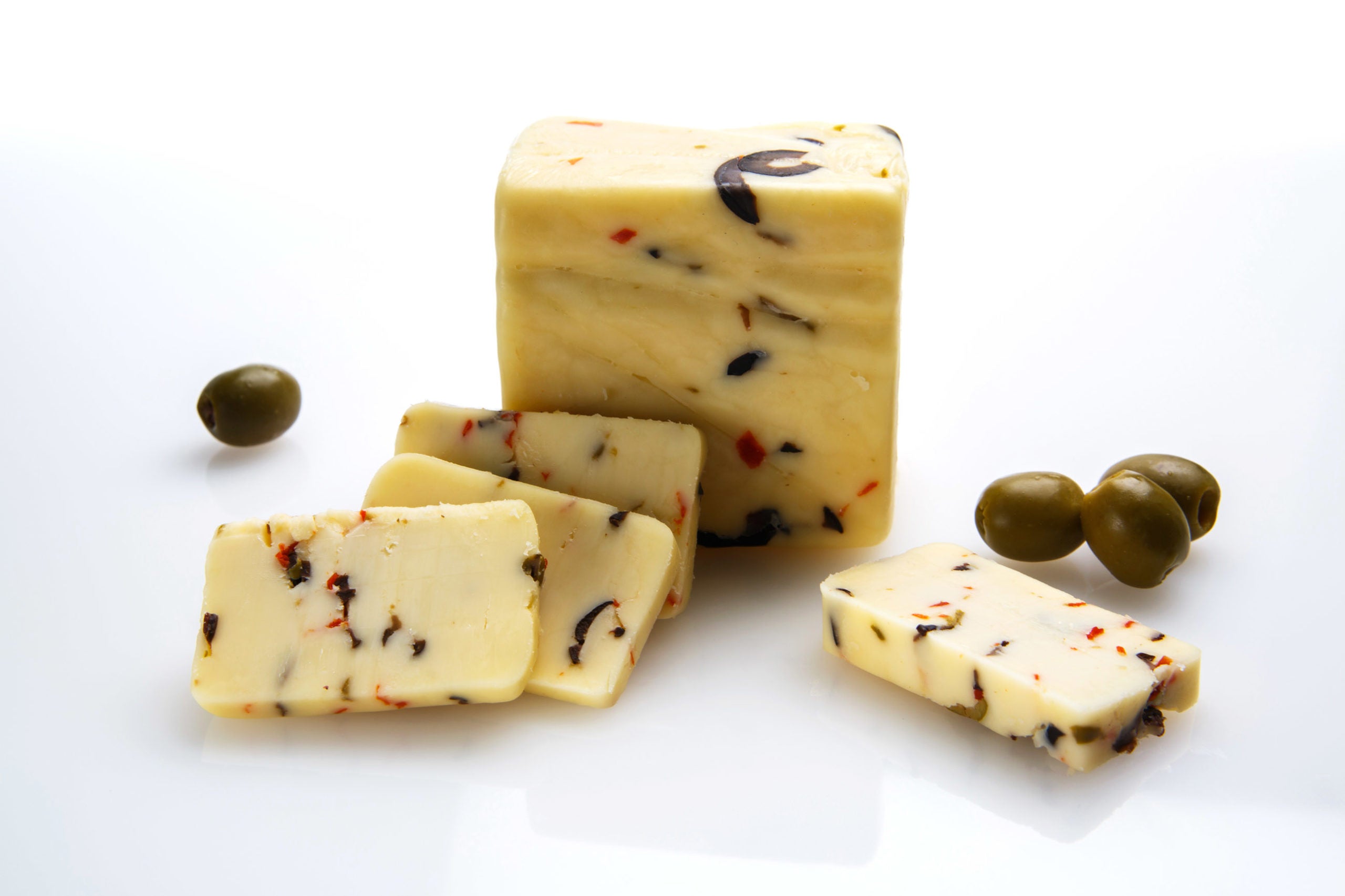 A block of Olive White Cheddar cheese with chopped olives, showcasing its creamy texture and rich color.