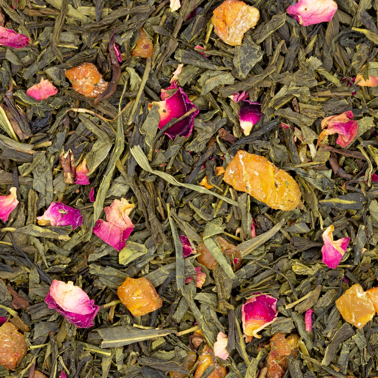 Tasse de thé vert à la poire fraîche, avec des morceaux de poire et des pétales de rose, sur une table en bois.