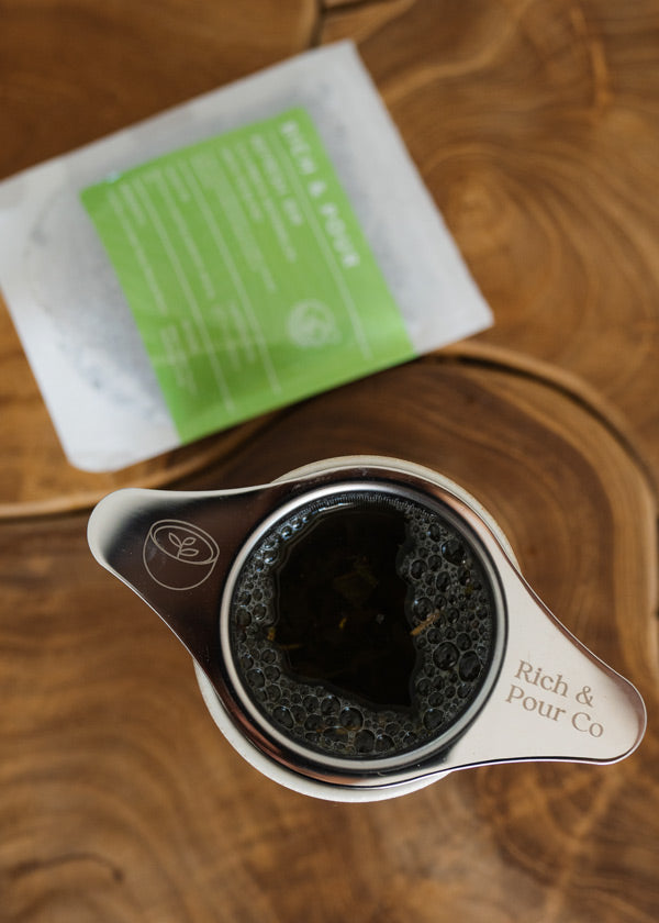 A vibrant cup of cucumber and watermelon green tea blend, showcasing fresh cucumber slices and watermelon accents.