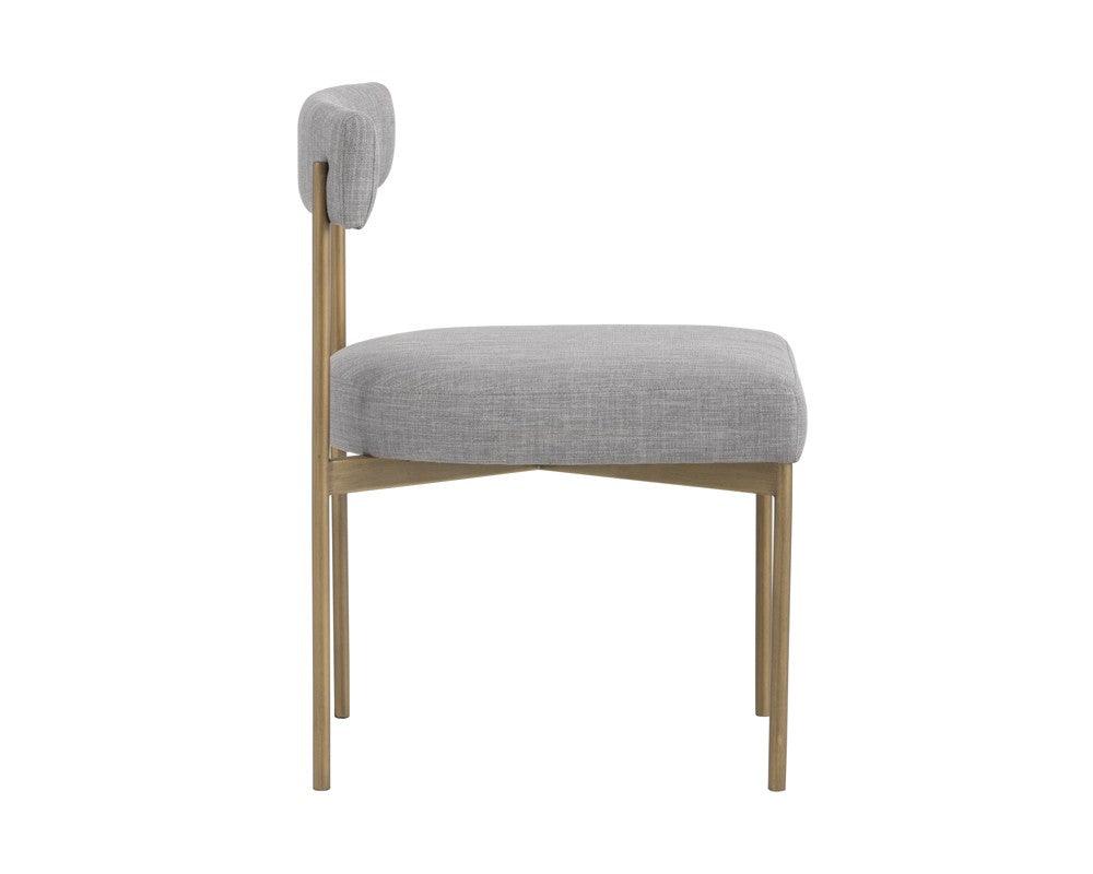 Seneca Dining Chair featuring an antique brass frame and arena cement fabric, showcasing a modern open back design.