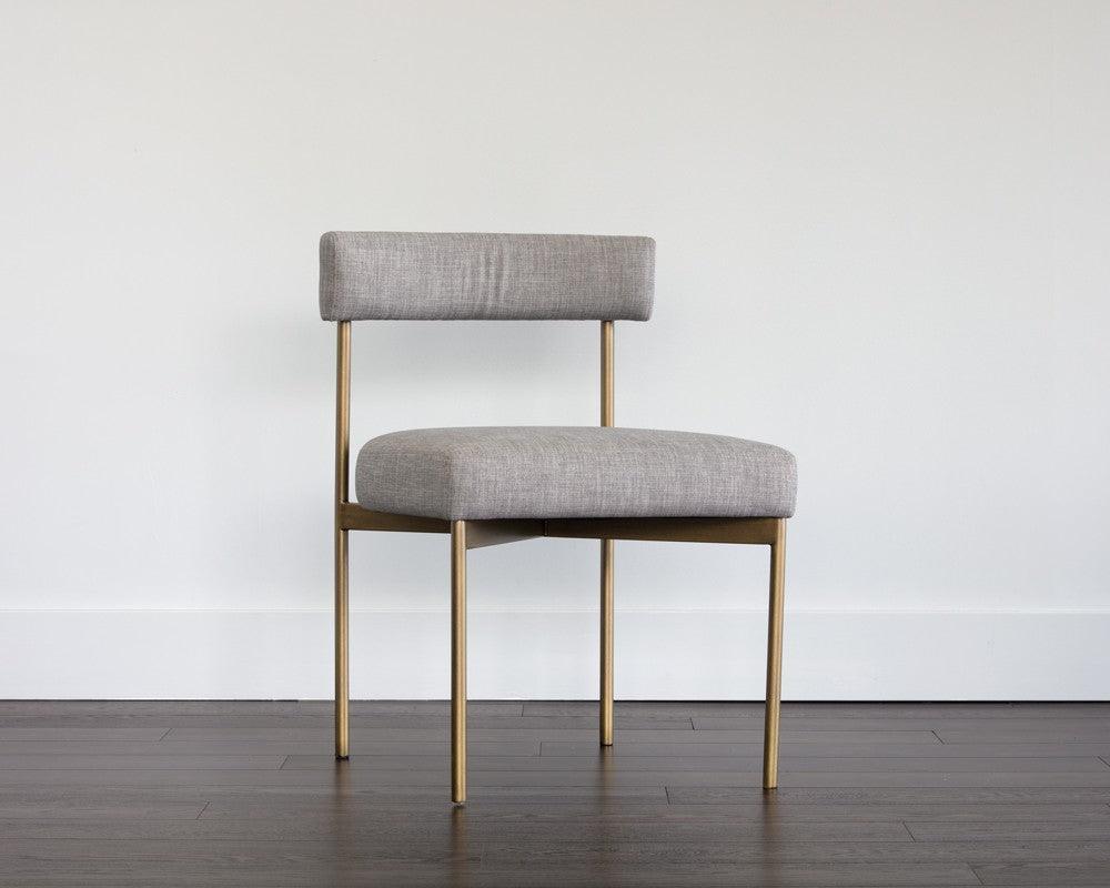 Seneca Dining Chair featuring an antique brass frame and arena cement fabric, showcasing a modern open back design.