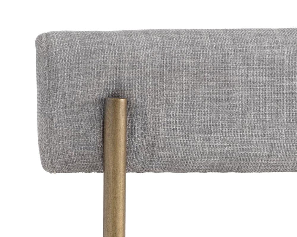 Seneca Dining Chair featuring an antique brass frame and arena cement fabric, showcasing a modern open back design.