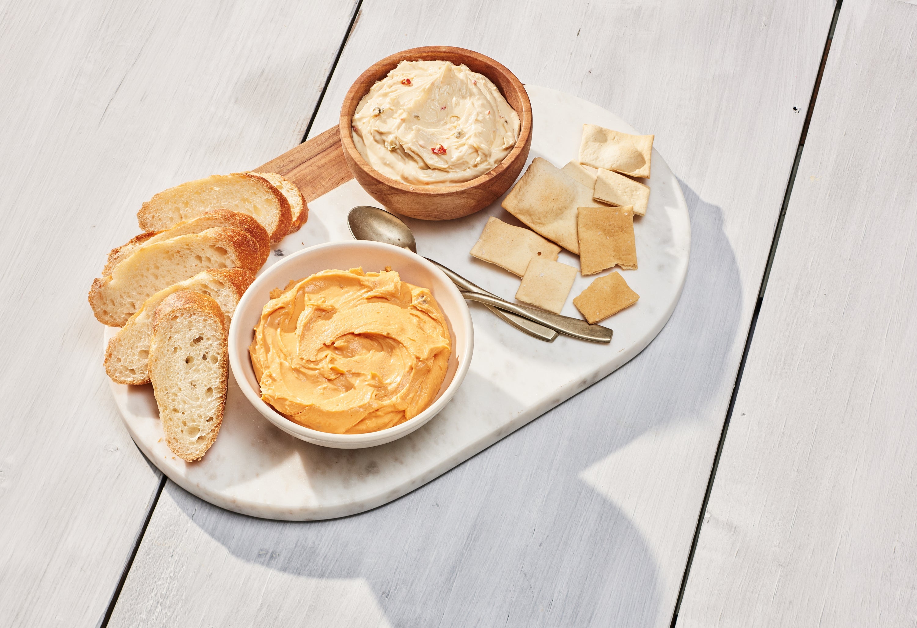 A jar of Spicy Beer Cheese Spread featuring aged cheddar, cayenne pepper, and garlic, perfect for snacking or cooking.