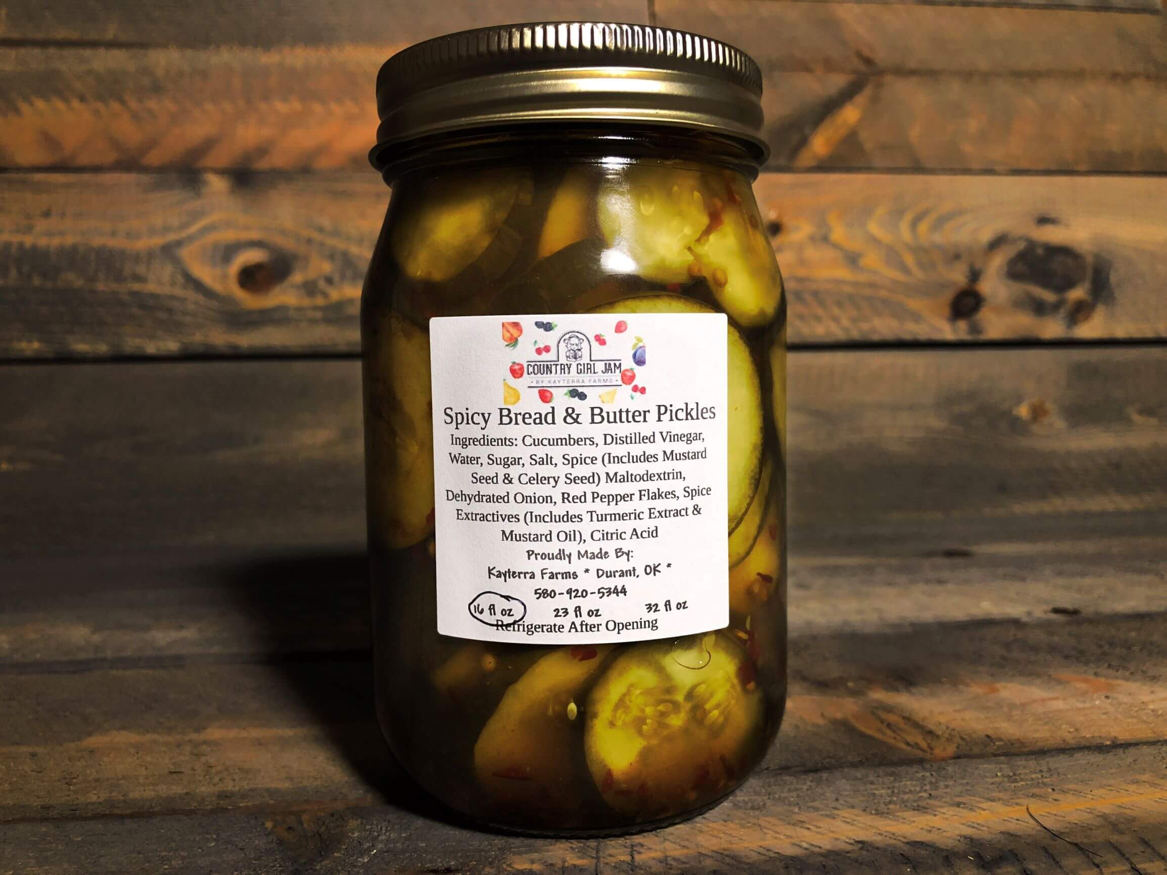 A jar of Spicy Bread & Butter Pickles showcasing vibrant green cucumber slices with a hint of red pepper flakes, perfect for sandwiches and snacks.