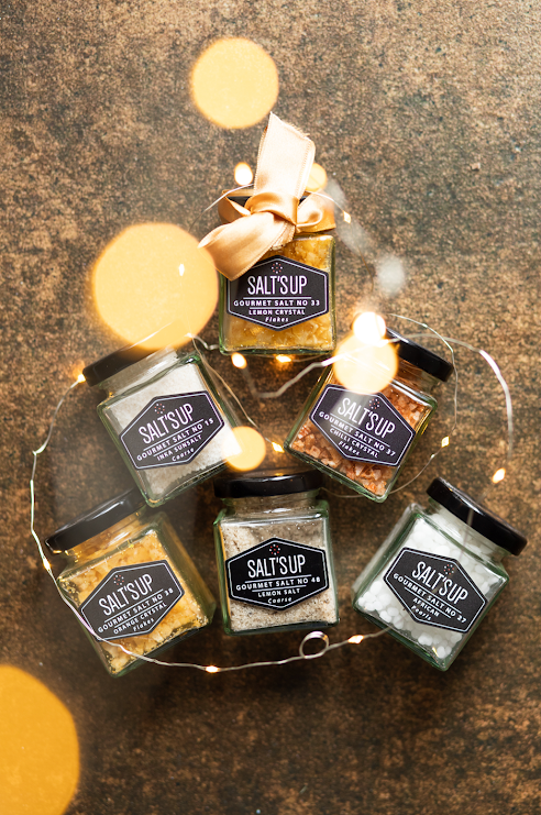 Starter set of gourmet salts featuring Crystal White, Black Lava, Crystal Pink, Alaea Coarse, Bamboo Jade, and Kala Namak salts in jars.