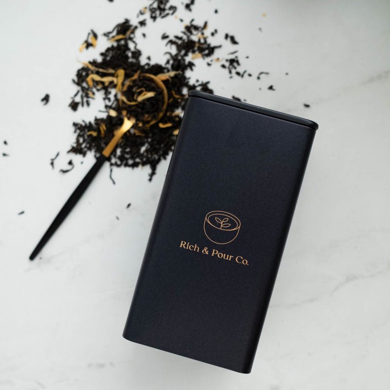 A set of stylish tea storage tins made from recycled steel, available in cubed, tall, and large sizes, showcasing their airtight design.