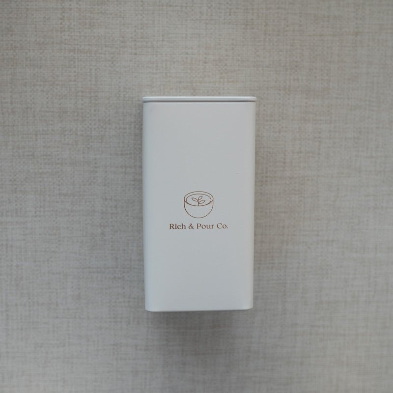 A set of stylish tea storage tins made from recycled steel, available in cubed, tall, and large sizes, showcasing their airtight design.