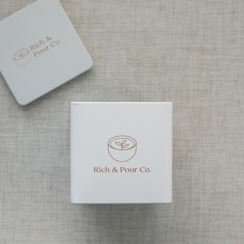 A set of stylish tea storage tins made from recycled steel, available in cubed, tall, and large sizes, showcasing their airtight design.