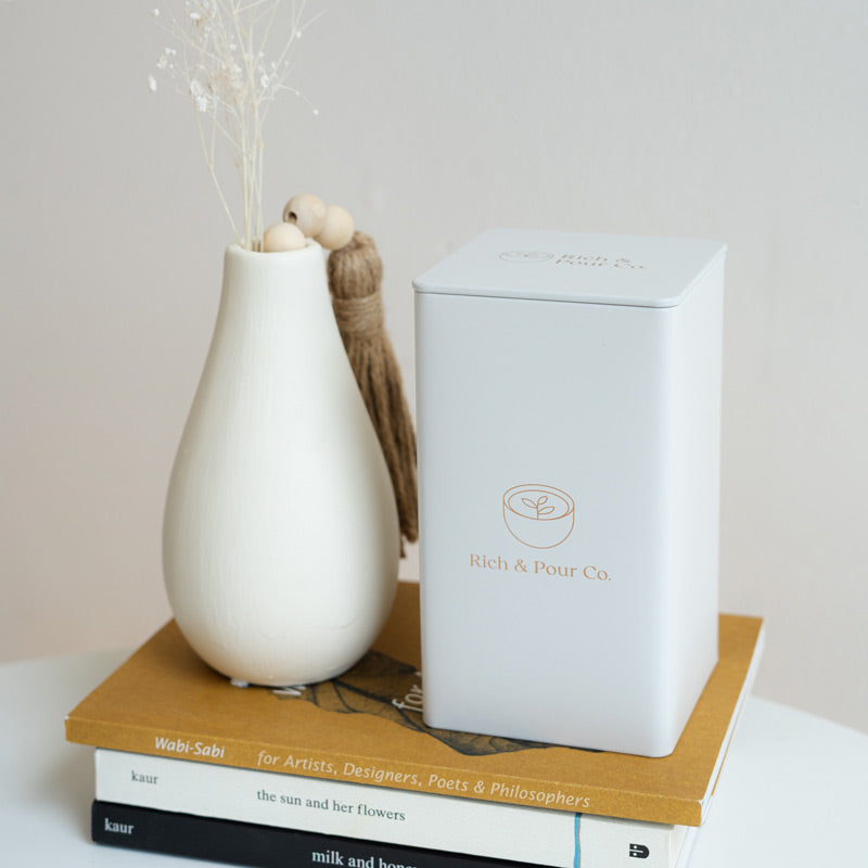 A set of stylish tea storage tins made from recycled steel, available in cubed, tall, and large sizes, showcasing their airtight design.