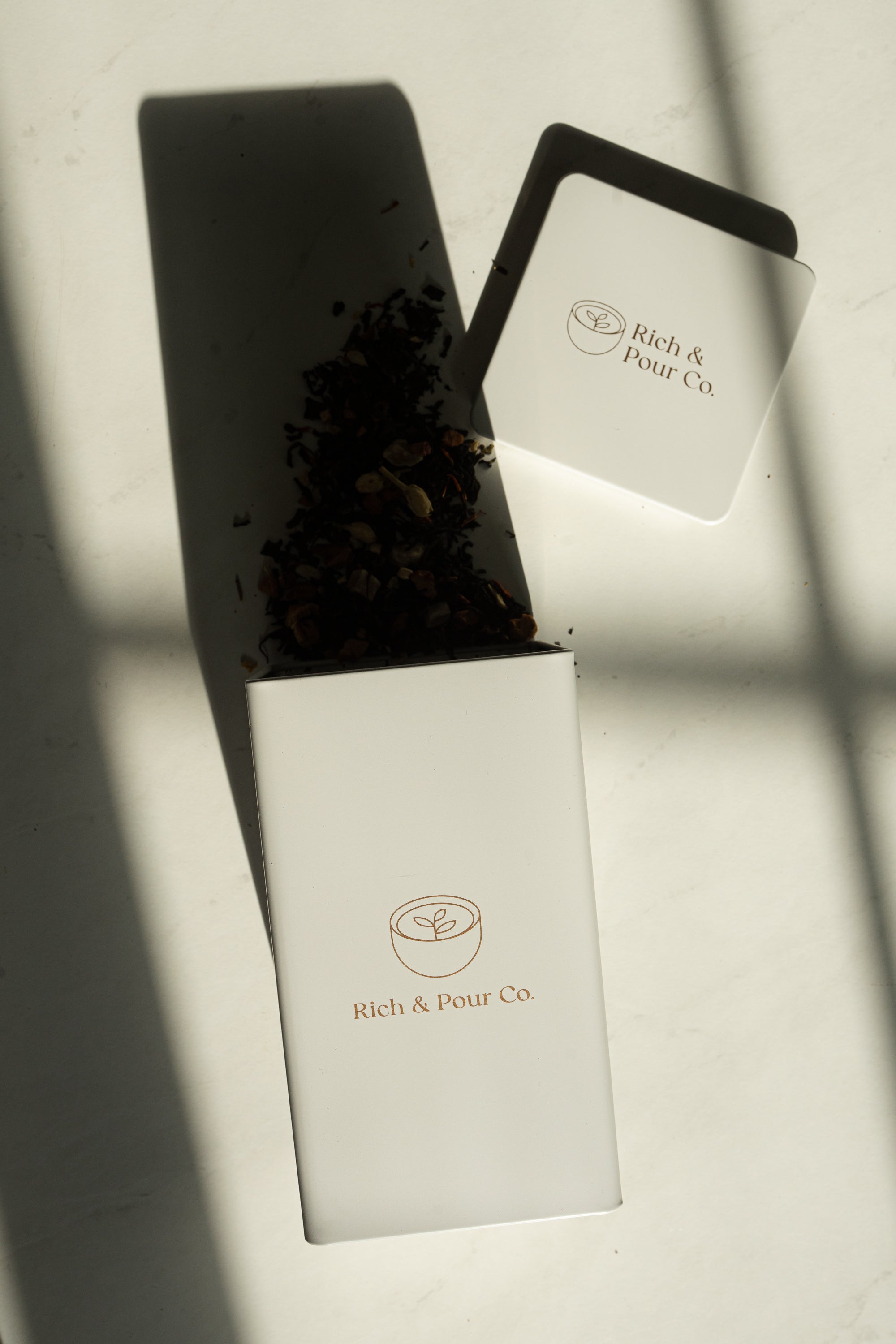 A set of stylish tea storage tins made from recycled steel, available in cubed, tall, and large sizes, showcasing their airtight design.