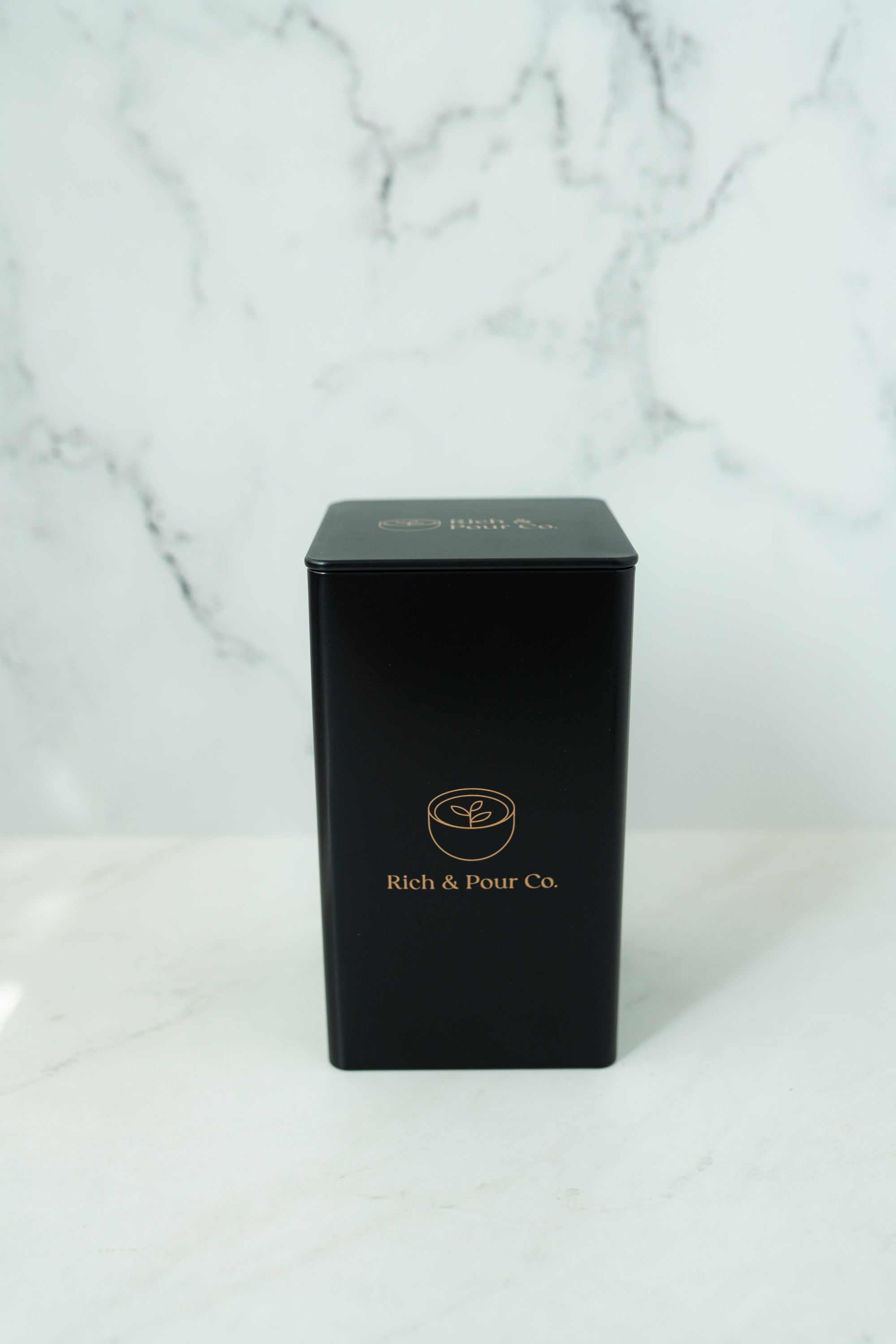 A set of stylish tea storage tins made from recycled steel, available in cubed, tall, and large sizes, showcasing their airtight design.