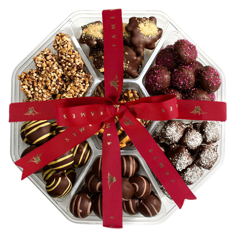 A large holiday gift basket filled with assorted chocolates and handcrafted chocolate logs, beautifully arranged for festive celebrations.