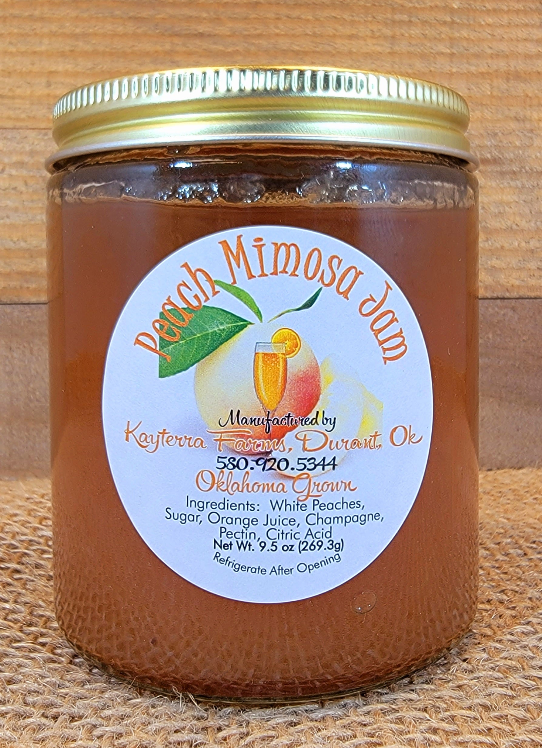 A refreshing glass of White Peach Mimosa garnished with a peach slice, showcasing its vibrant color and bubbly texture.