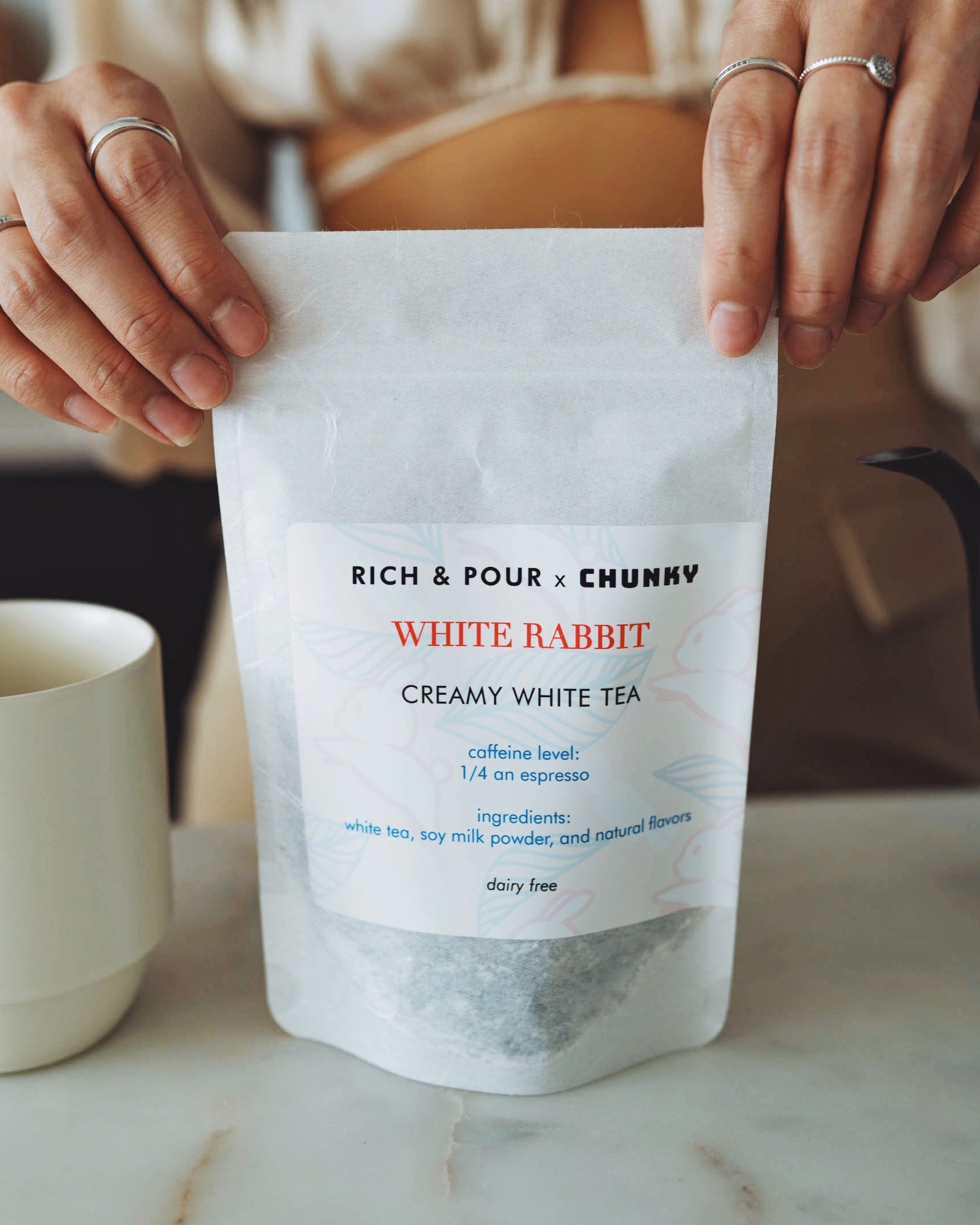 A beautifully packaged White Rabbit Creamy White Tea Blend featuring delicate white tea leaves and vibrant ingredients.