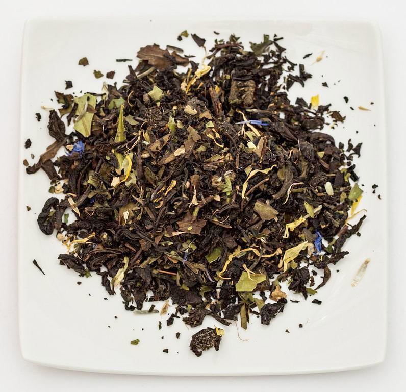 A beautifully packaged box of White Wine Infused Tea - Sexy Blonde featuring peach and stone fruit flavors, with tea leaves visible inside.