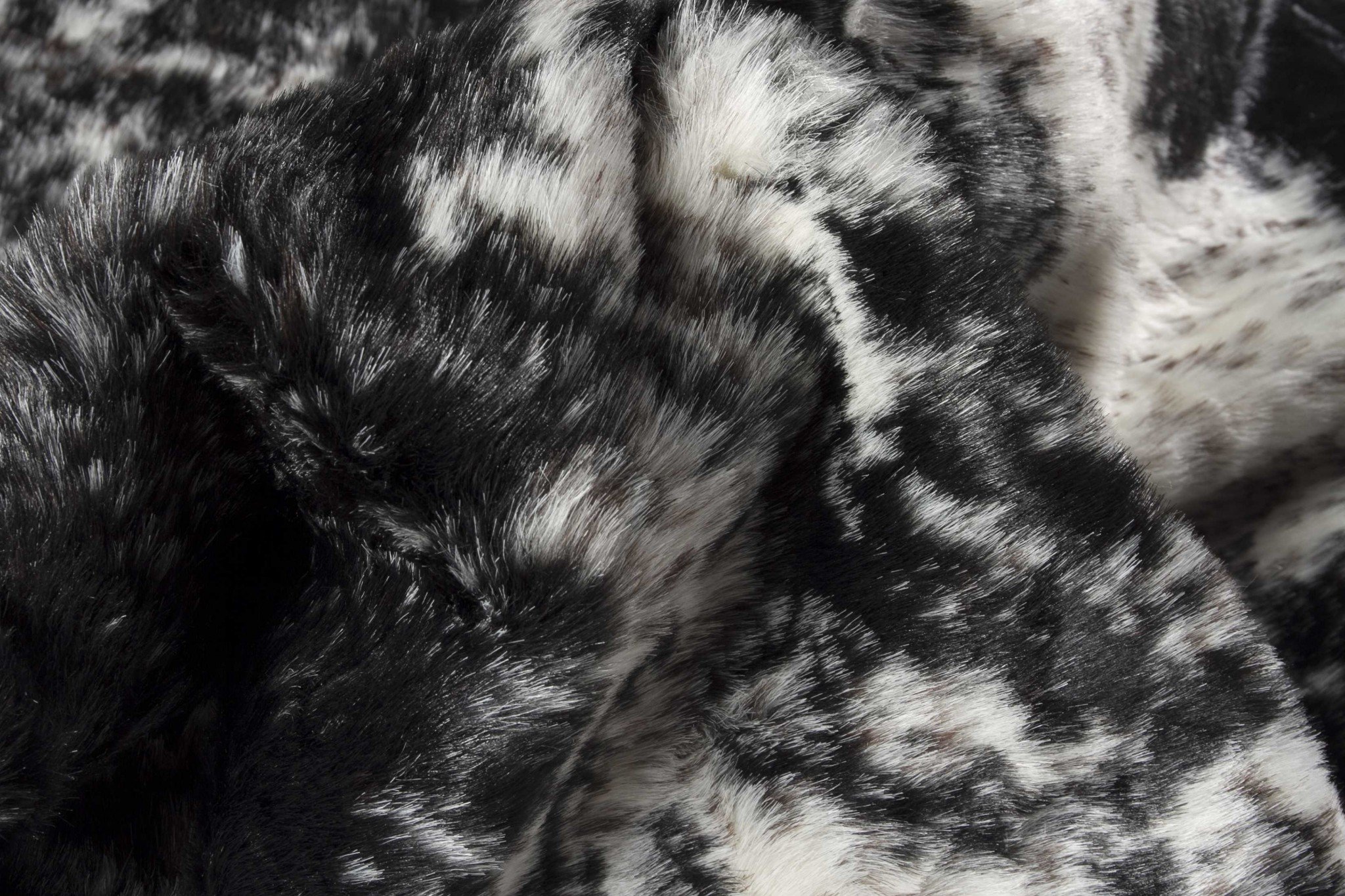 Luxurious 0.8in x 90in x 63in Acrylic Plush Polyester S&P Black rug, showcasing a soft faux cowhide texture in black and white.