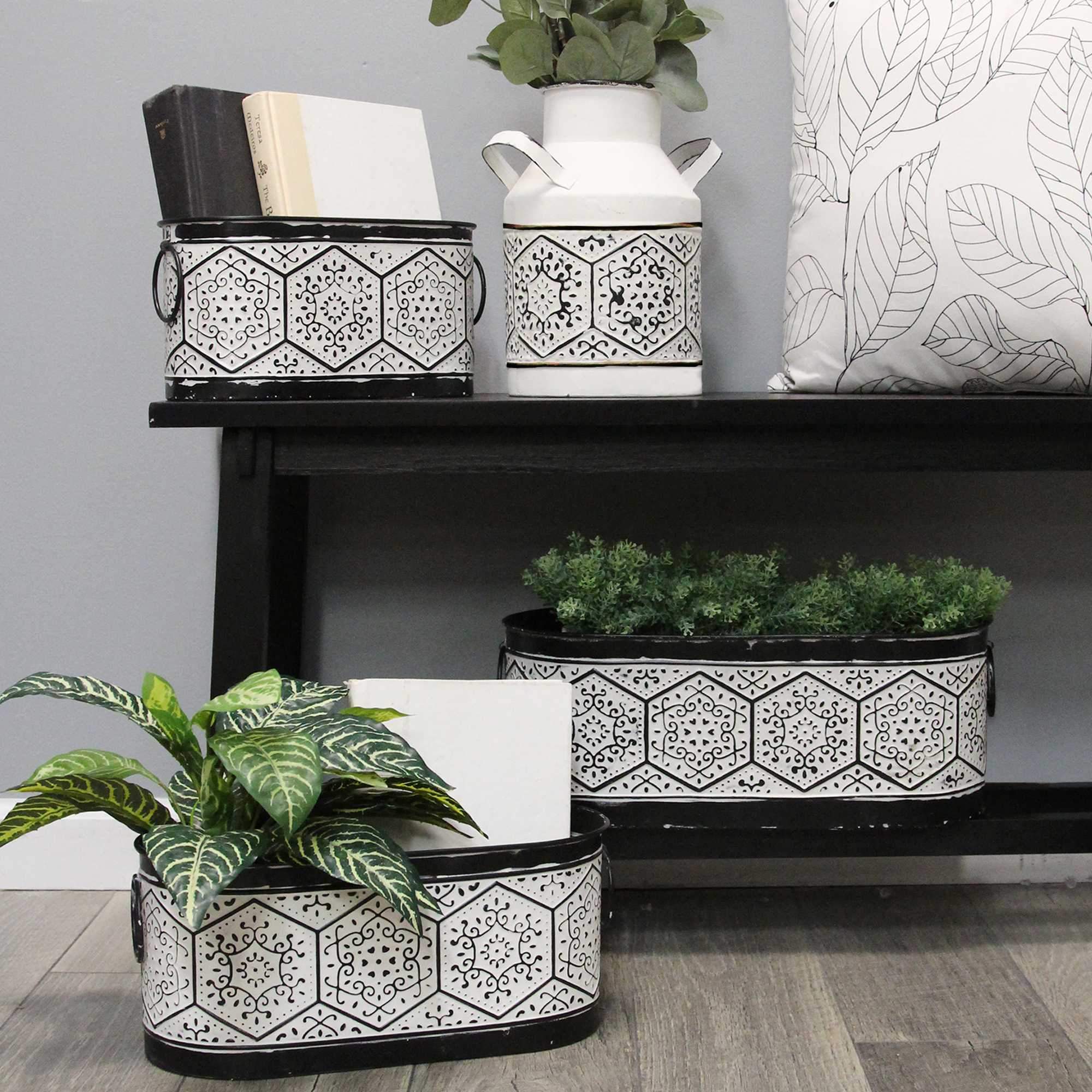 A 10-inch tall black and white metal vase with a distressed finish, featuring a textured pattern reminiscent of vintage milk jugs.