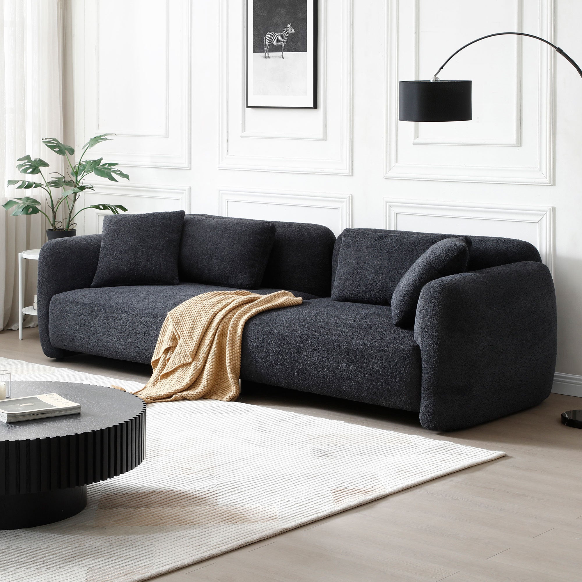 110.23 Inches Teddy Velvet Sofa in black with four plush pillows, showcasing a mid-century modern design suitable for living rooms.