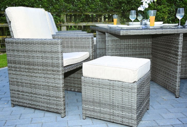 Gray 11-piece outdoor dining set featuring six chairs, four footstools, and a large dining table with glass top, perfect for outdoor gatherings.