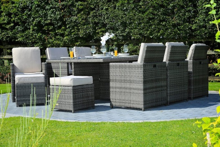 Gray 11-piece outdoor dining set featuring six chairs, four footstools, and a large dining table with glass top, perfect for outdoor gatherings.