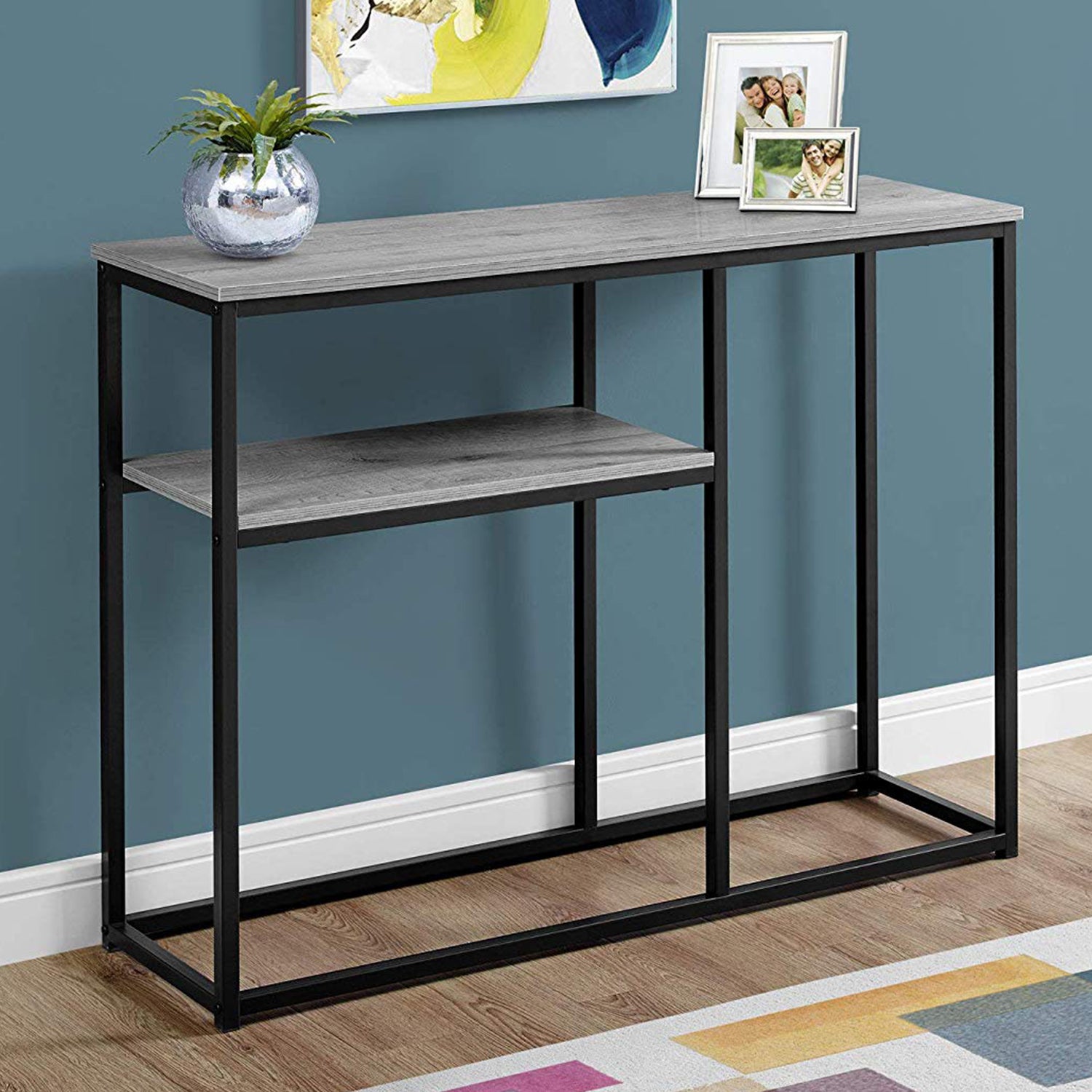 A sleek black metal accent table measuring 12x42x32 inches, showcasing a modern design suitable for various interior styles.
