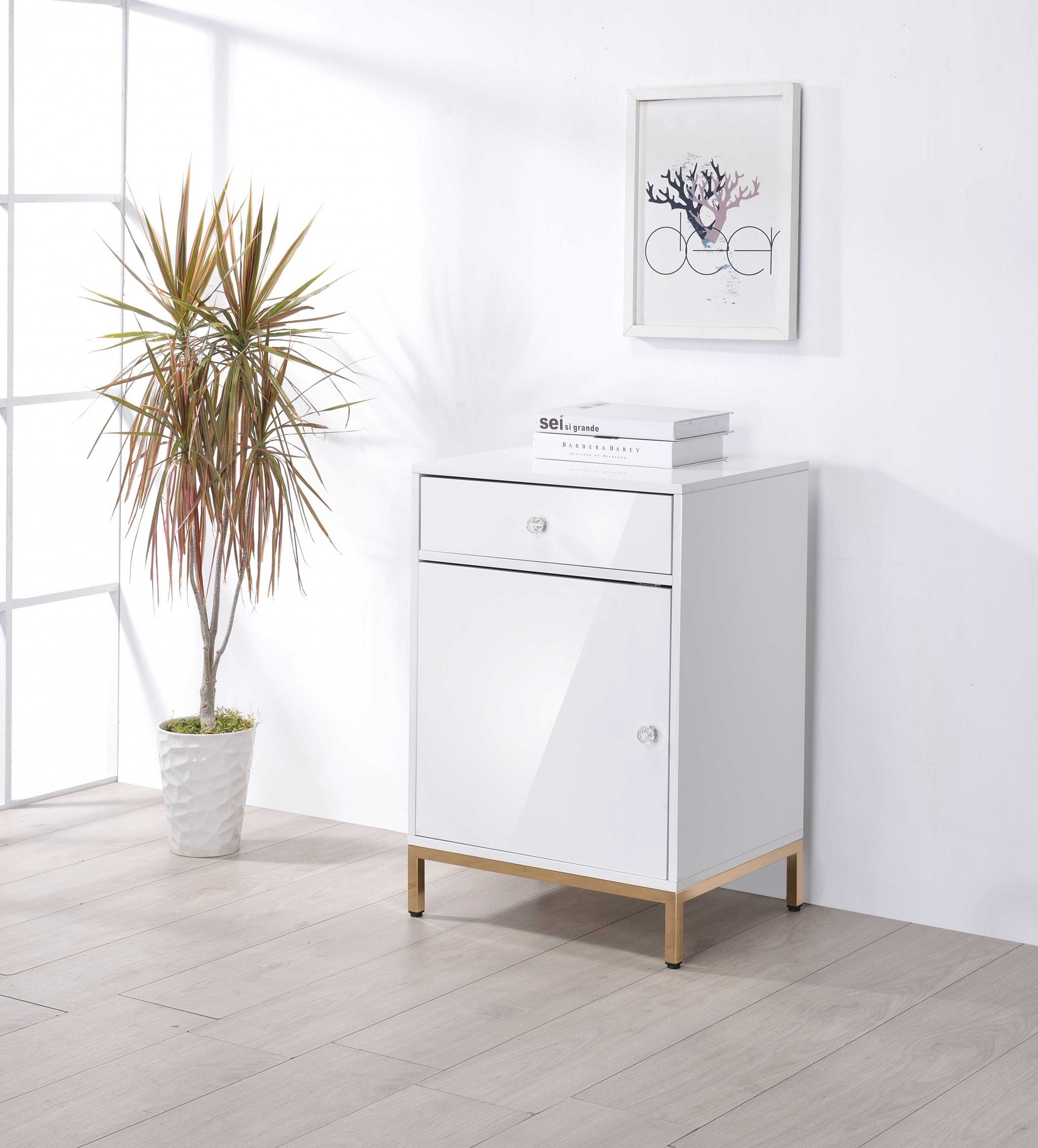 Elegant white high gloss cabinet with gold metal base, featuring a door and storage drawer, perfect for modern office decor.