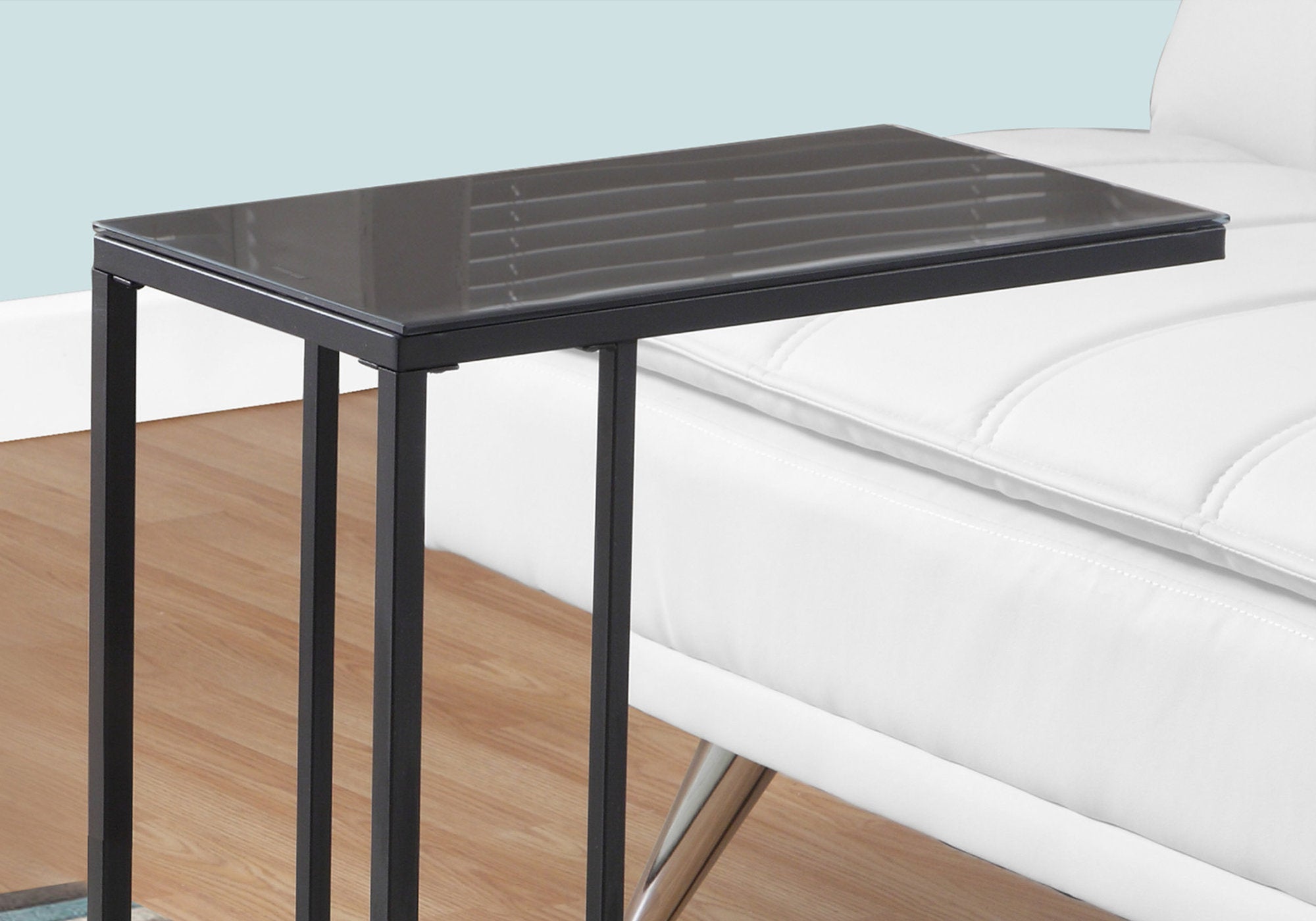 Elegant black metal accent table with tempered glass top, showcasing a modern design suitable for any living space.