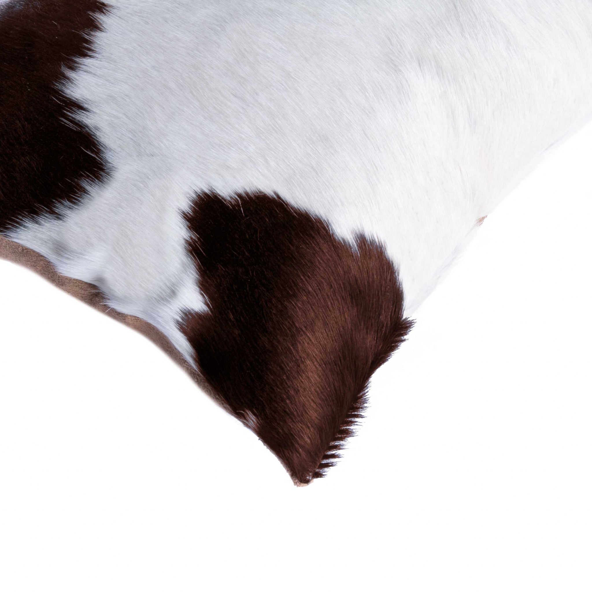 Luxurious 18x18 inches white and brown cowhide pillow with unique mottling and soft microsuede backing, featuring a hidden zipper closure.