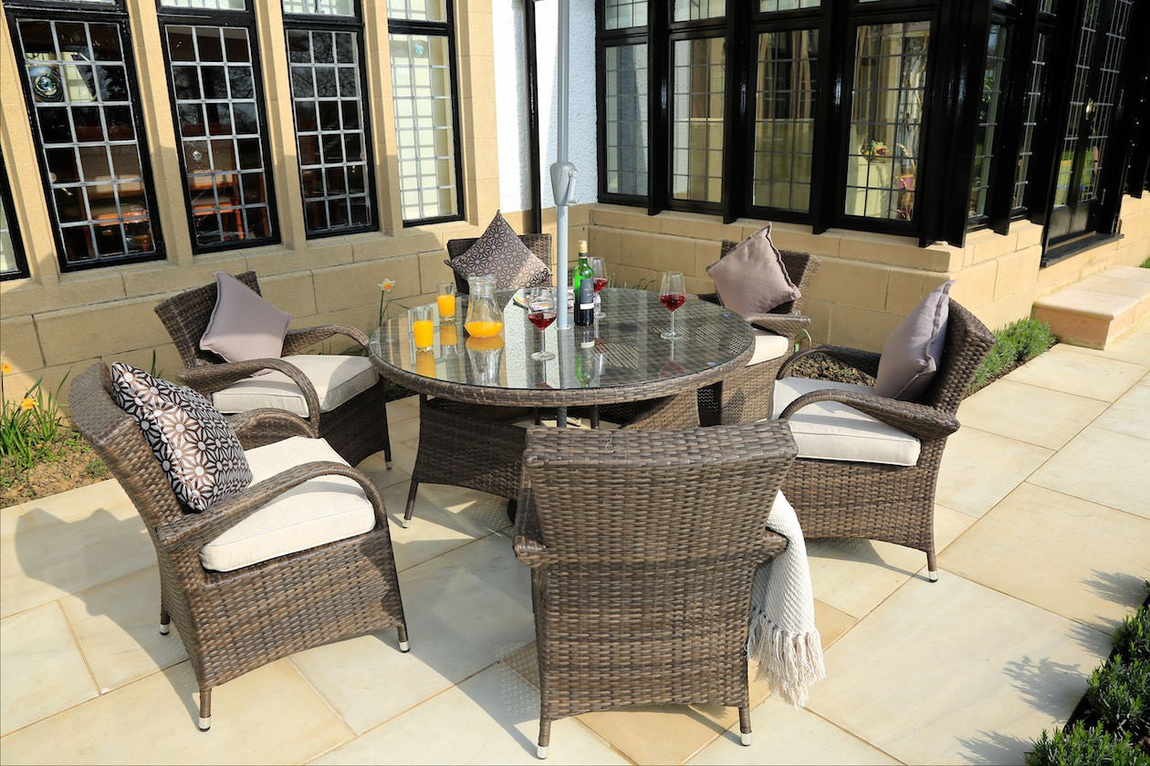 Brown 7-piece outdoor dining set featuring six chairs and a round table with tempered glass top, perfect for outdoor dining.