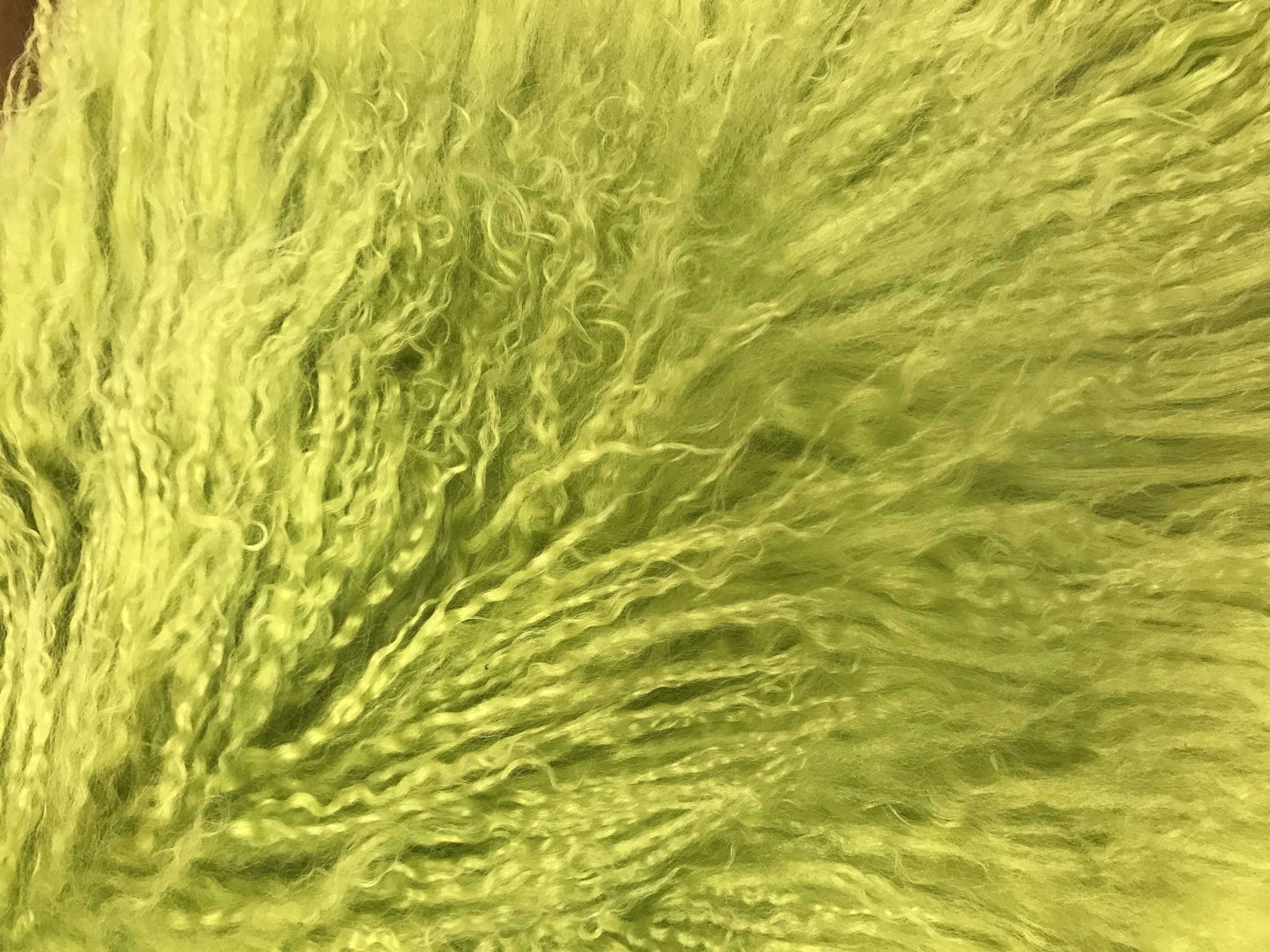 A luxurious 24-inch lime green genuine Tibetan lamb fur pillow with a soft microsuede backing, showcasing its plush texture and vibrant color.
